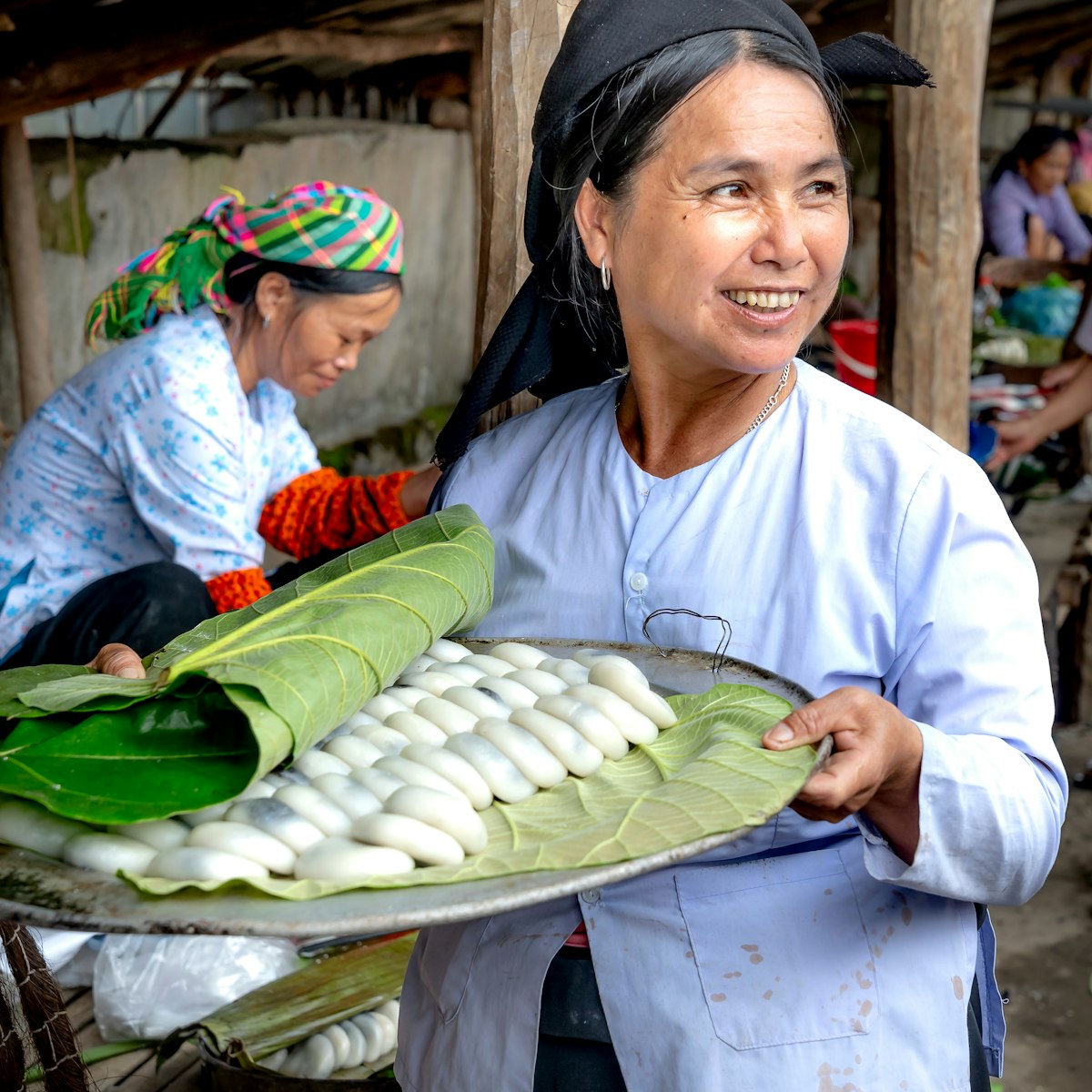 Lang Son province, Vietnam. the beauty of a rural woman selling homemade rice cakes filled with black sugar at the market.