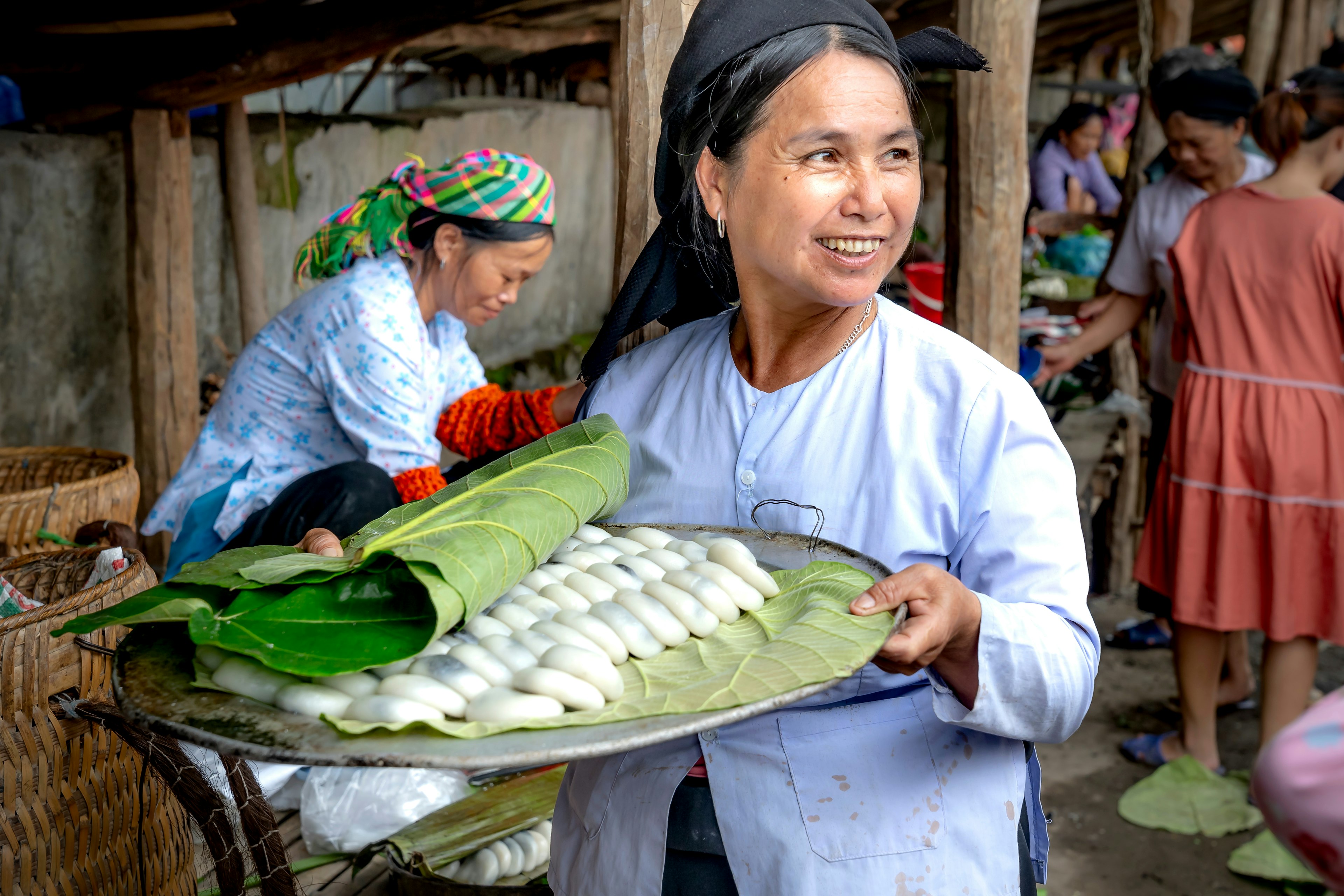 A woman sells homemade rice cakes filled with black sugar at the market in Lang Son province, Vietnam