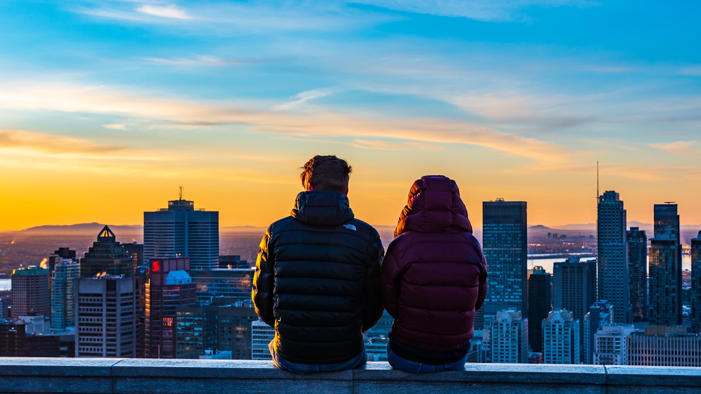Montreal, Canada - april 2021: Back view of a couple sitting next to each other on the stone wall of the Kondiaronk belvedere and amiring the colorful view over Montreal's skyline, during sunrise; Shutterstock ID 1964403721; full: 65050; gl: Online ed; netsuite: Montreal things to do; your: Claire Naylor
1964403721