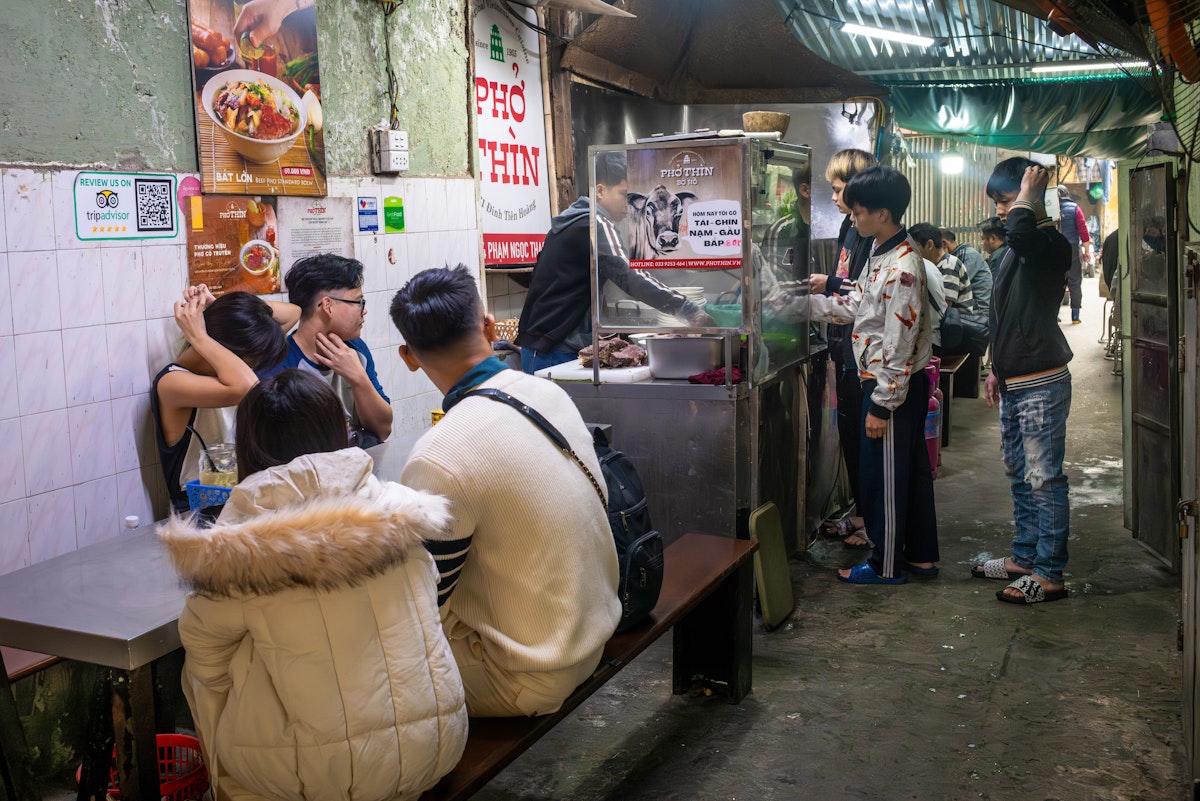 Young people wait at Pho Thin for their traditional bowls of pho, or noodle soup, in Hanoi, Vietnam. Pho can be eaten at any time of day.
