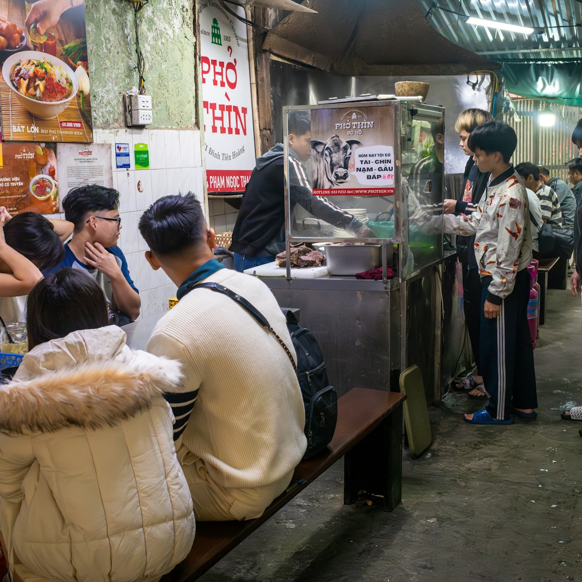 Young people wait at Pho Thin for their traditional bowls of pho, or noodle soup, in Hanoi, Vietnam. Pho can be eaten at any time of day.