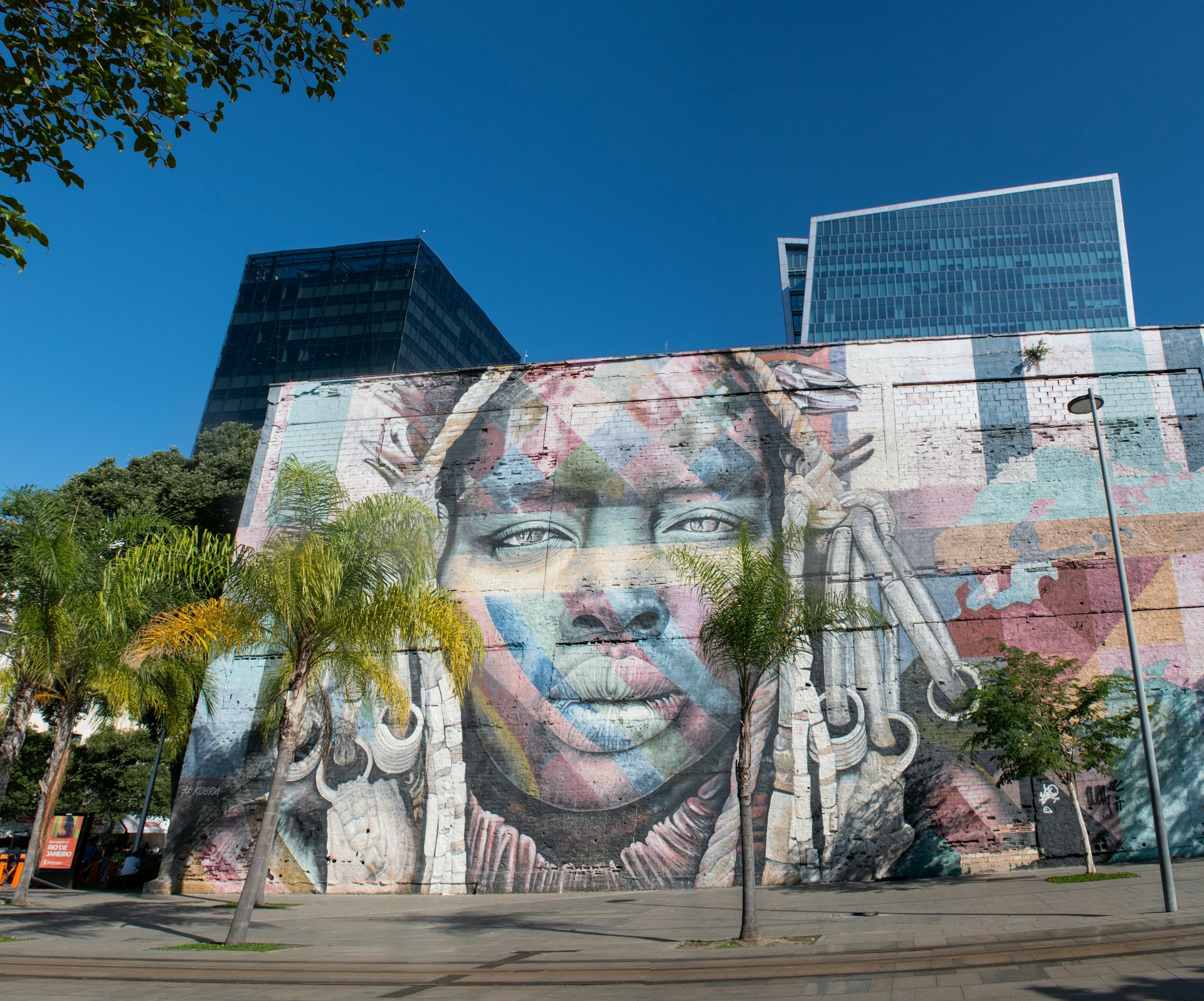 A mural of a woman's face fills the whole side of a building