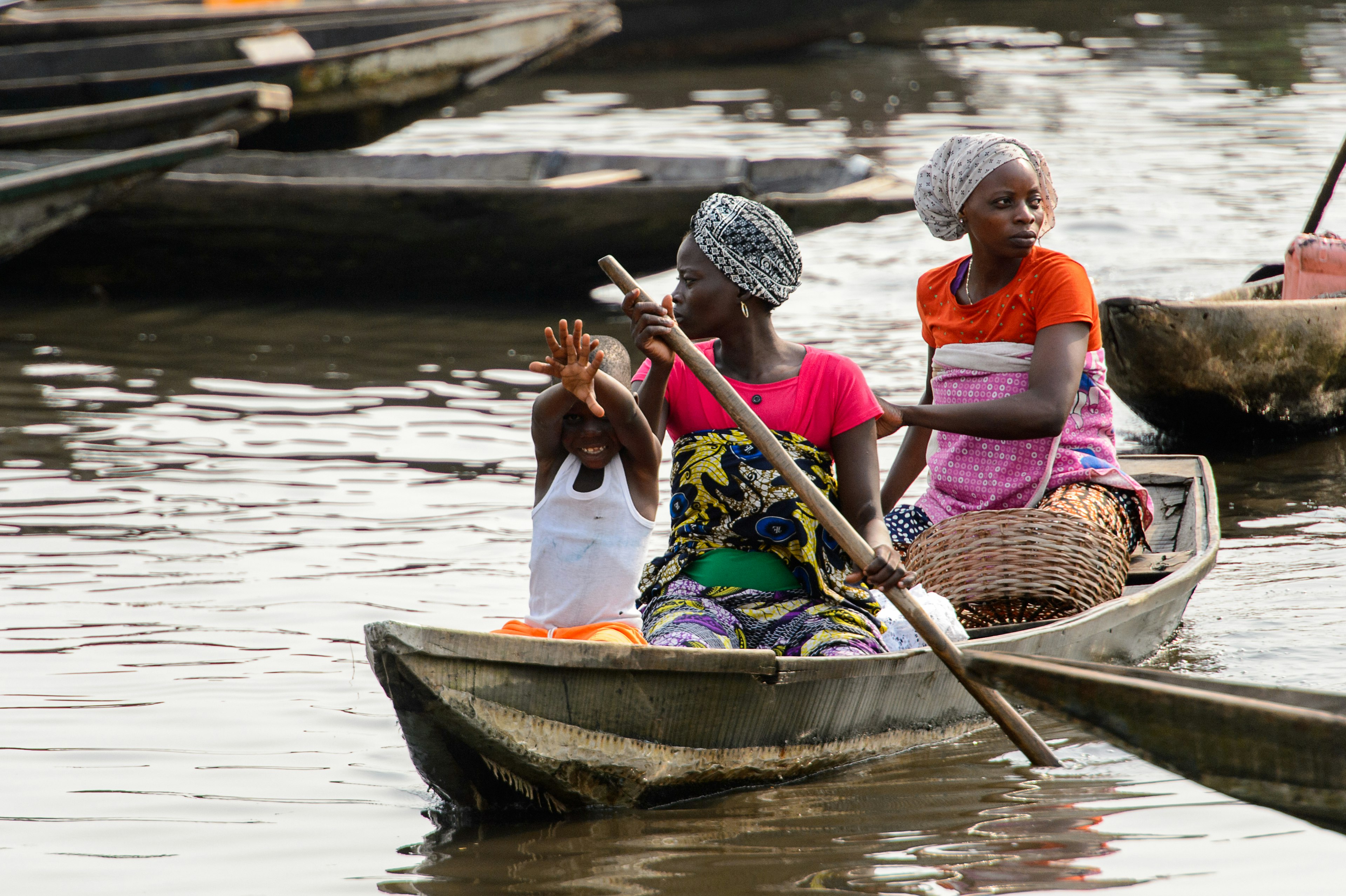 A Beninese family in a wooden boat crossing Lake Nokoue in Benin