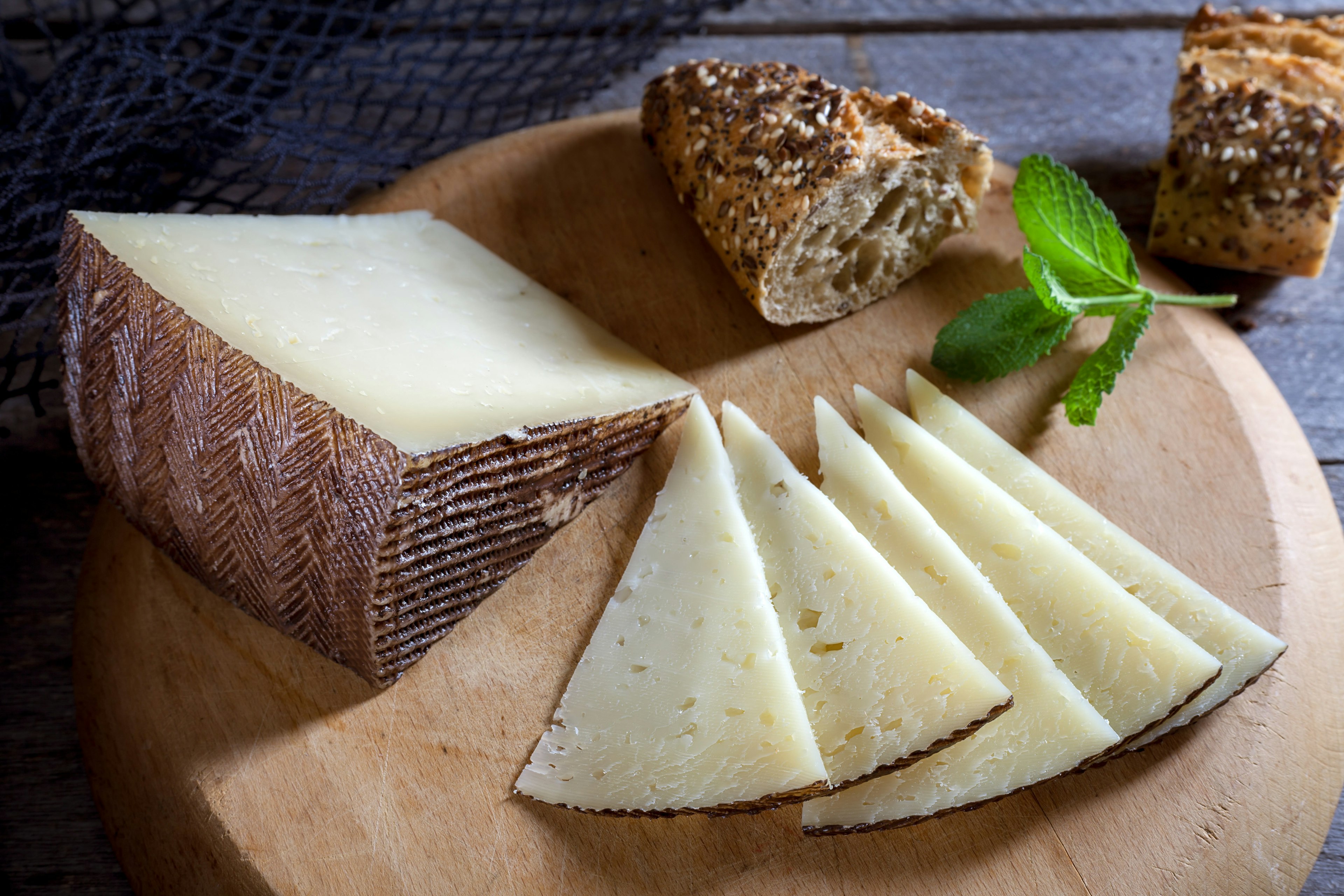 Spanish cheese on a chopping board with a hunk of bread