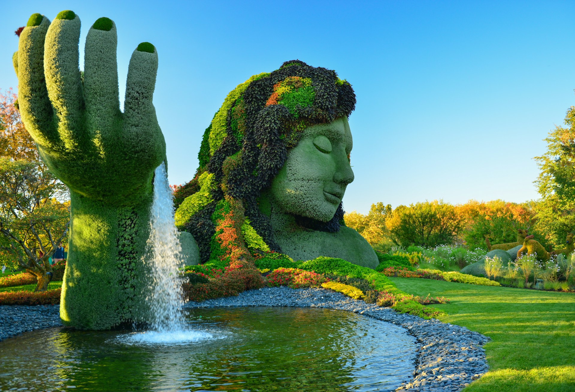 A giant woman with her hand in the air made entirely of shrubs, leaves, bushes and trees on show at the Montreal botanical garden