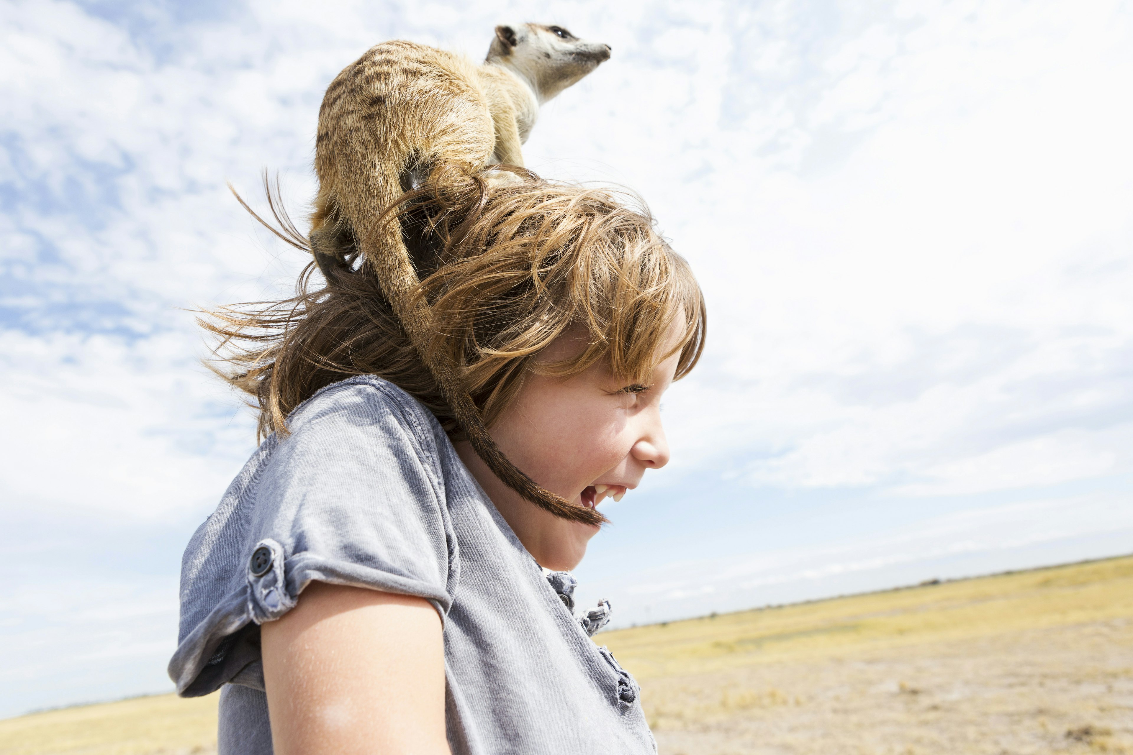 Five year old boy with Meerkat on his head, Kalahari Desert, Makgadikgadi Salt Pans, Botswana