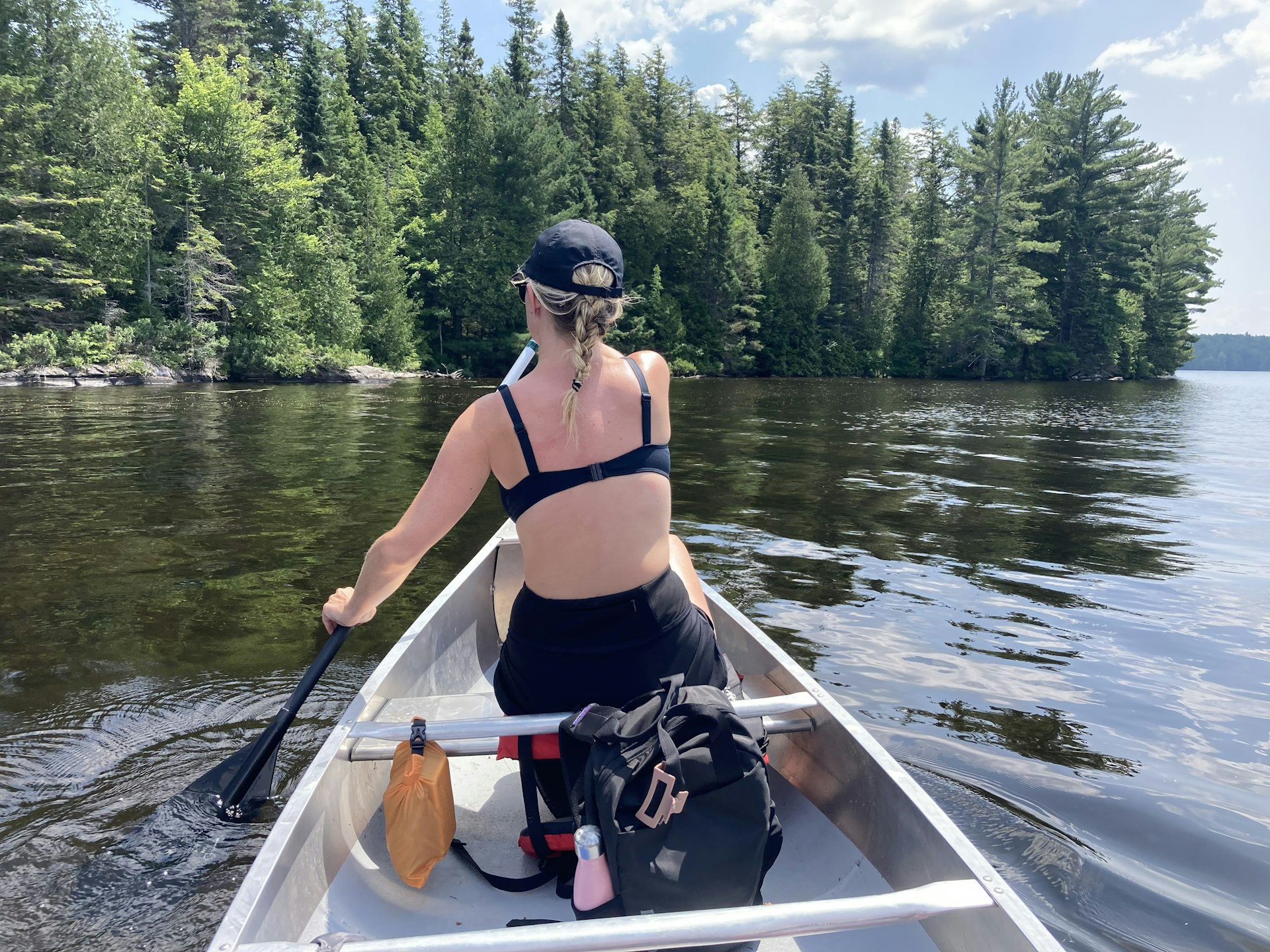  Lonely Planet writer Isabella Noble canoes across a lake in Algonquin Provincial Park, Canada and we see her from behind