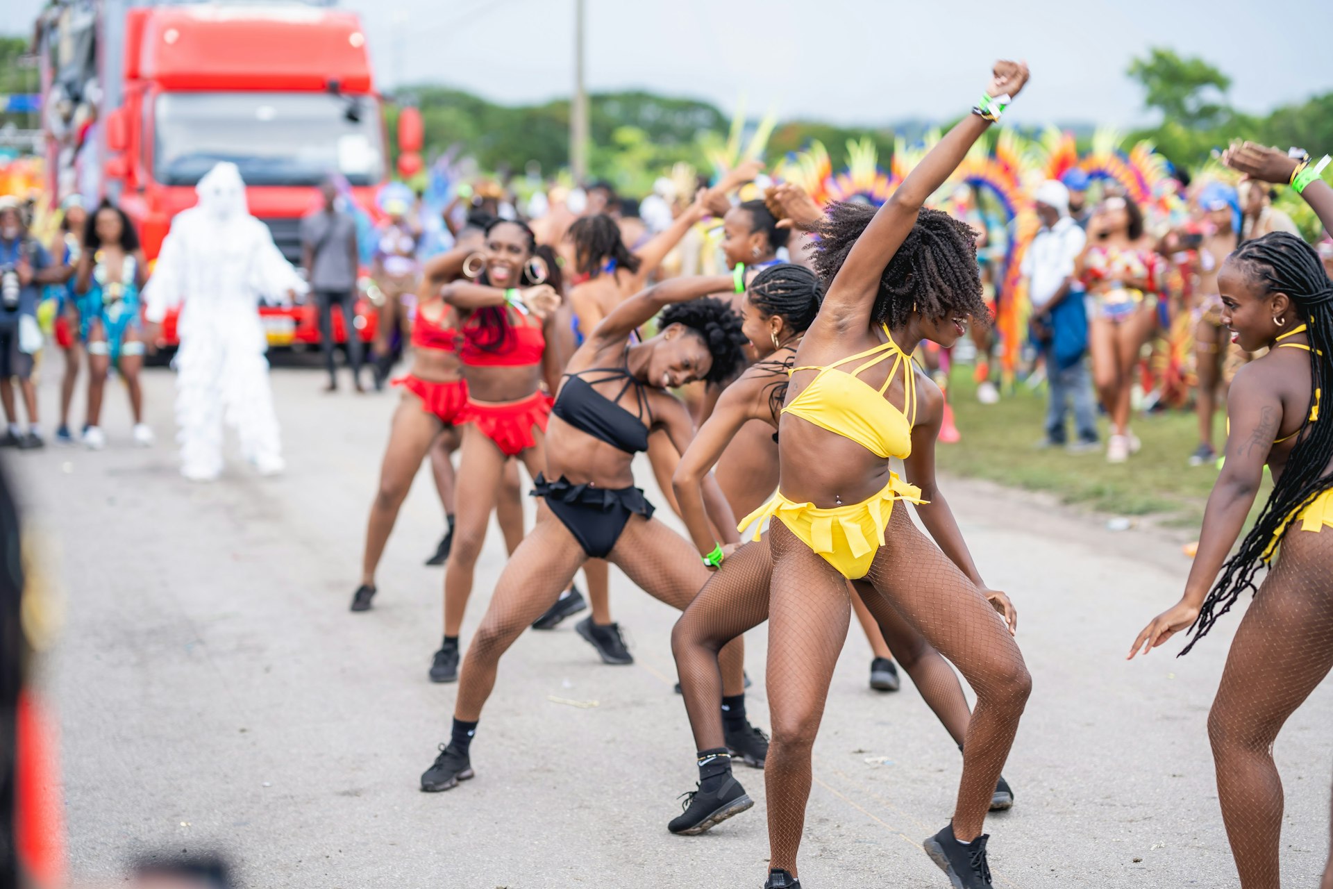 A line of women dance in a parade for Crop Over
