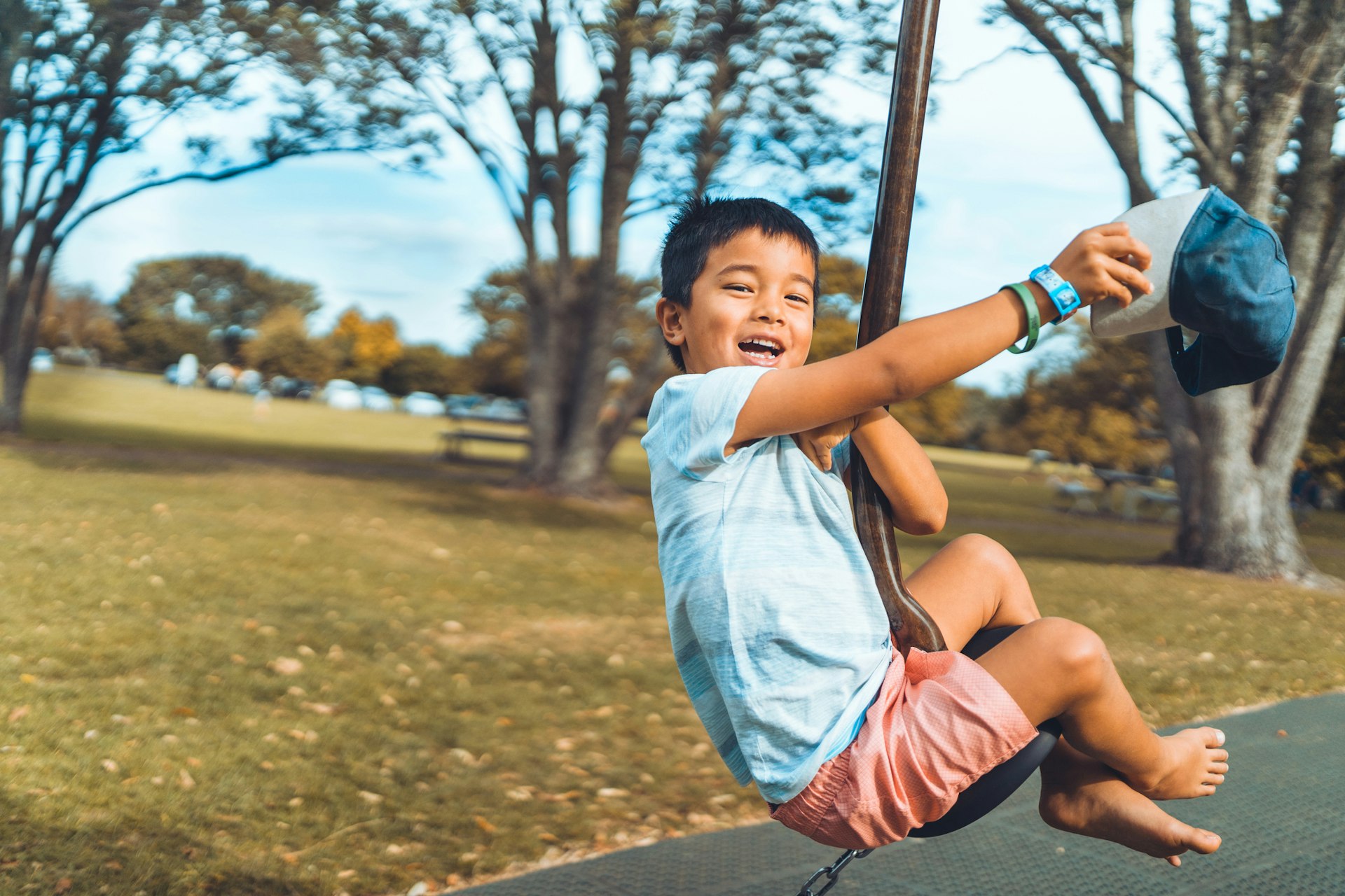 Kid smiling on a flying fox ride in an Auckland playground, New Zealand.