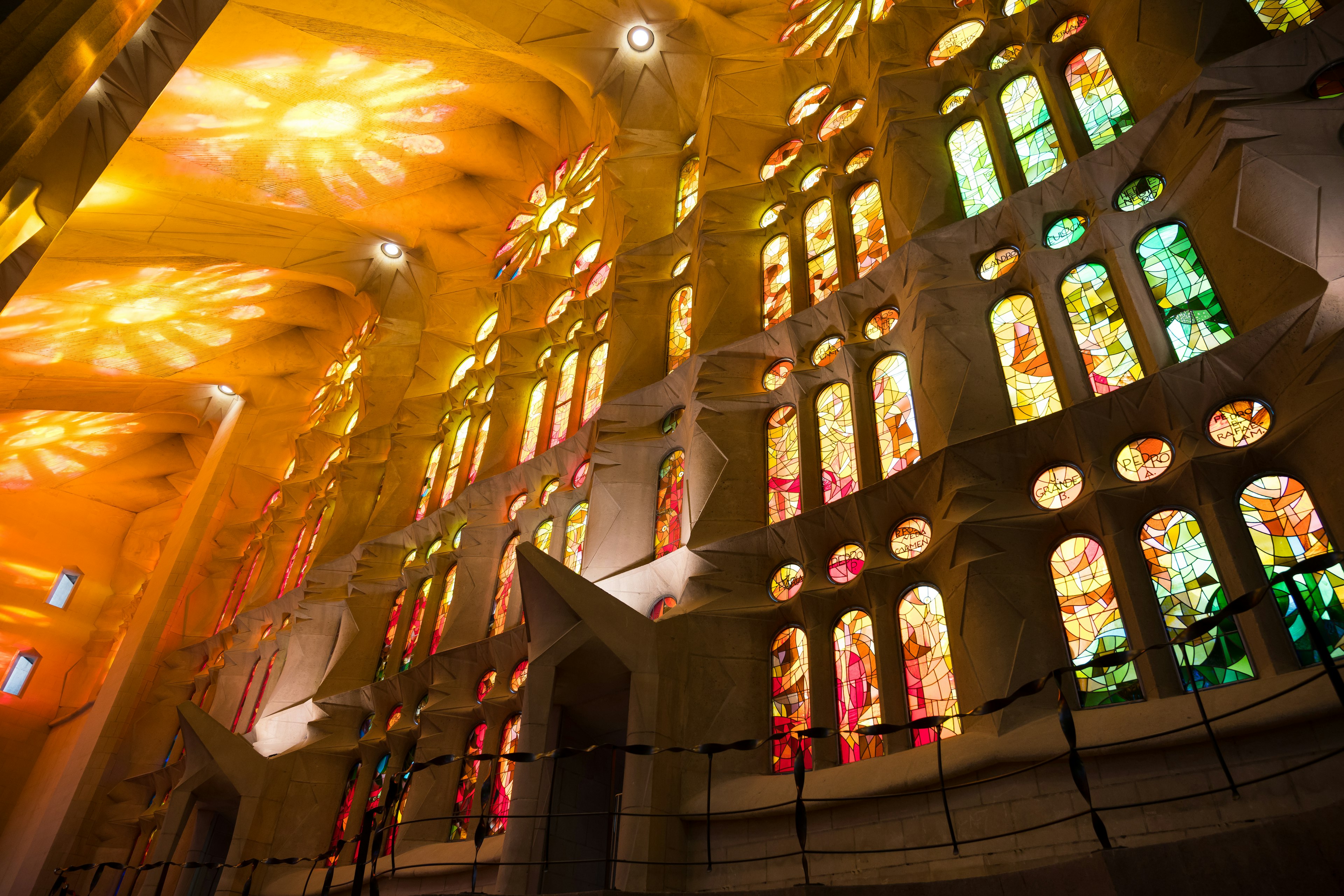 Light pours in through stained glass windows in the nave of La Sagrada Família, Barcelona, Catalonia, Spain