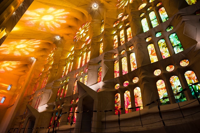 An interior view of the La Sagrada Familia with the light illuminating its stain glass windows