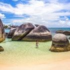 Indonesia, Bangka-Belitung, Belitung Island, woman wading in shallow water at beach with granite boulders
1205427427
