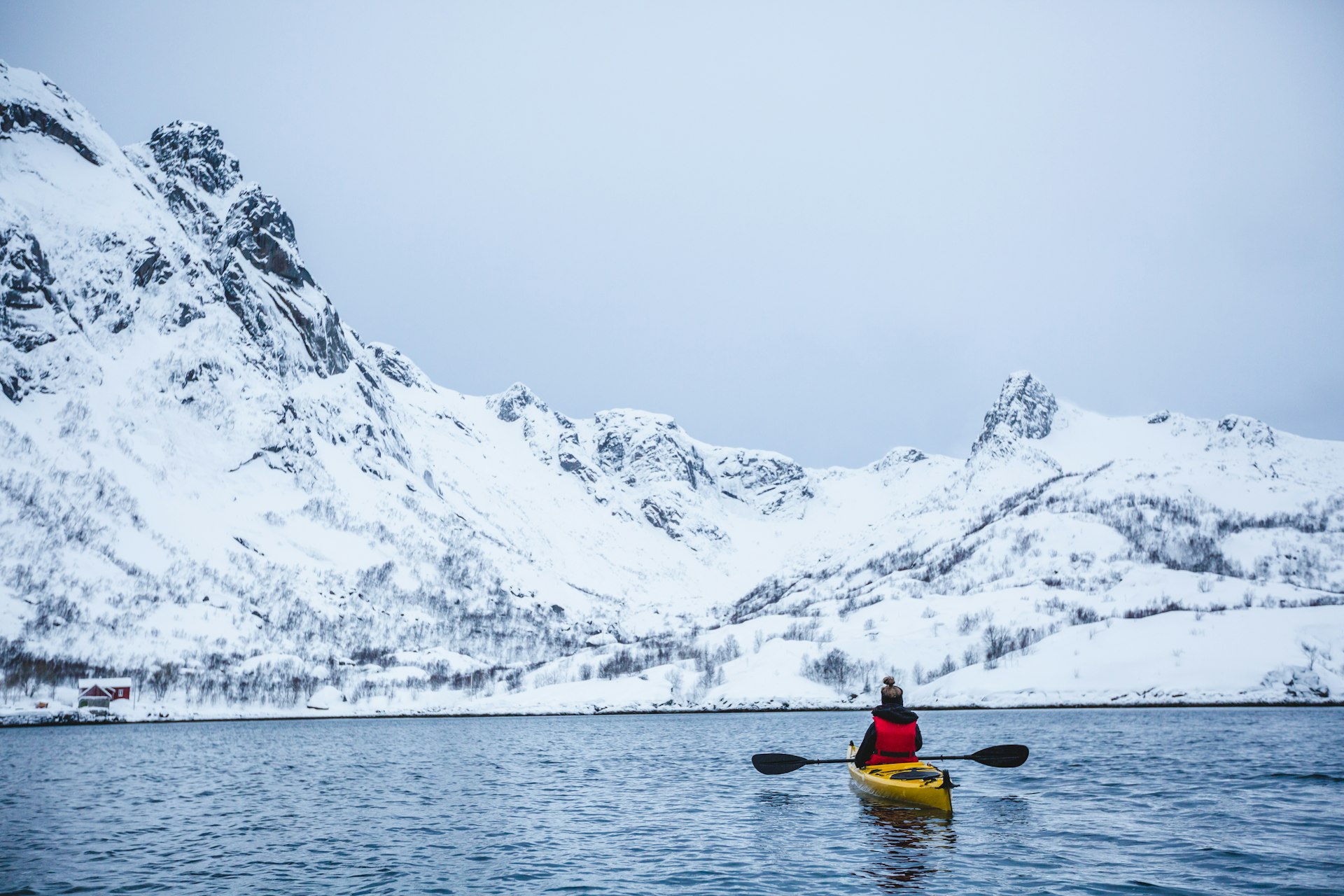 Rear view of woman kayaking in the Lofoten Islands, Norway
