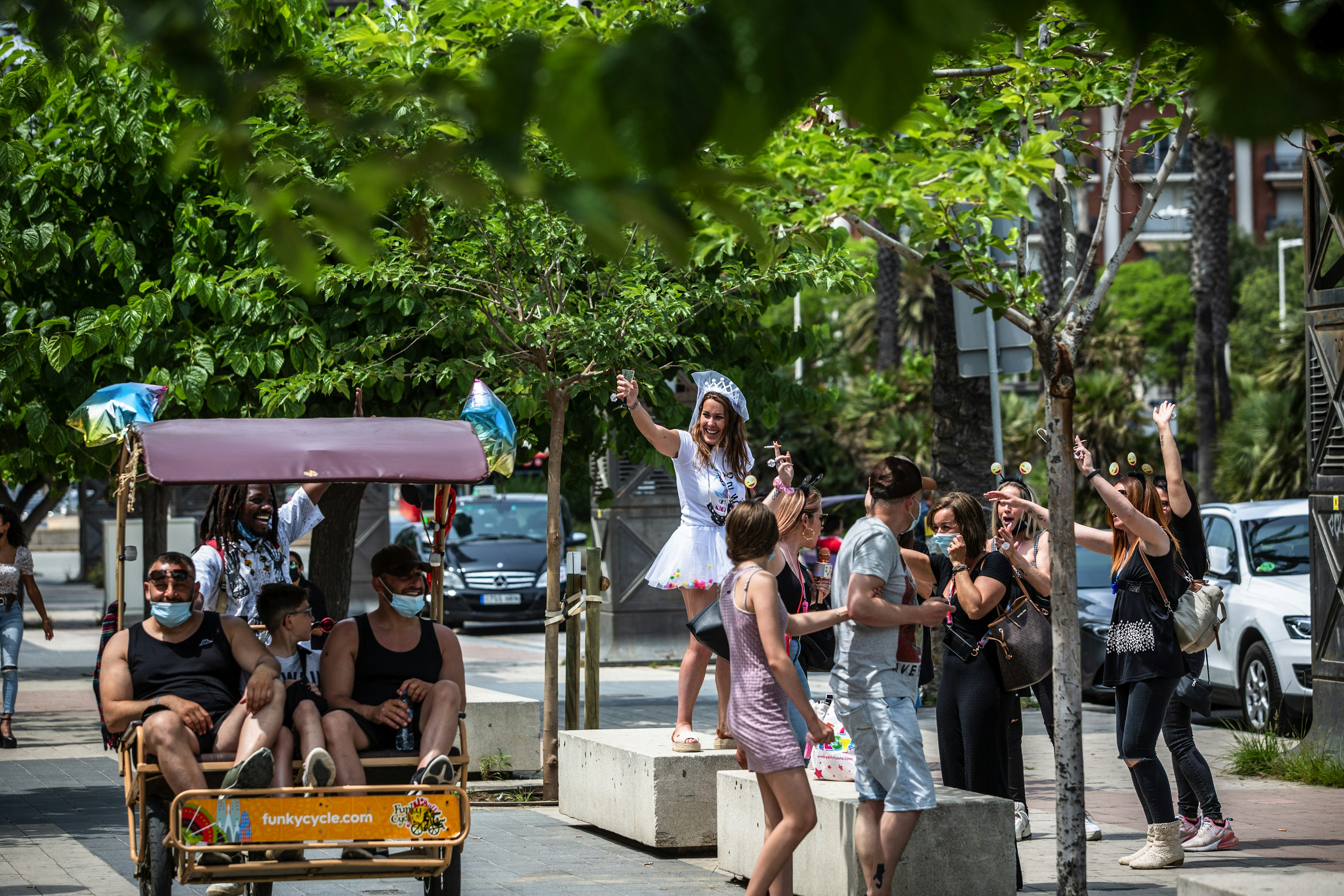 Tourists in a rickshaw pass holidaymakers in Barcelona, Spain