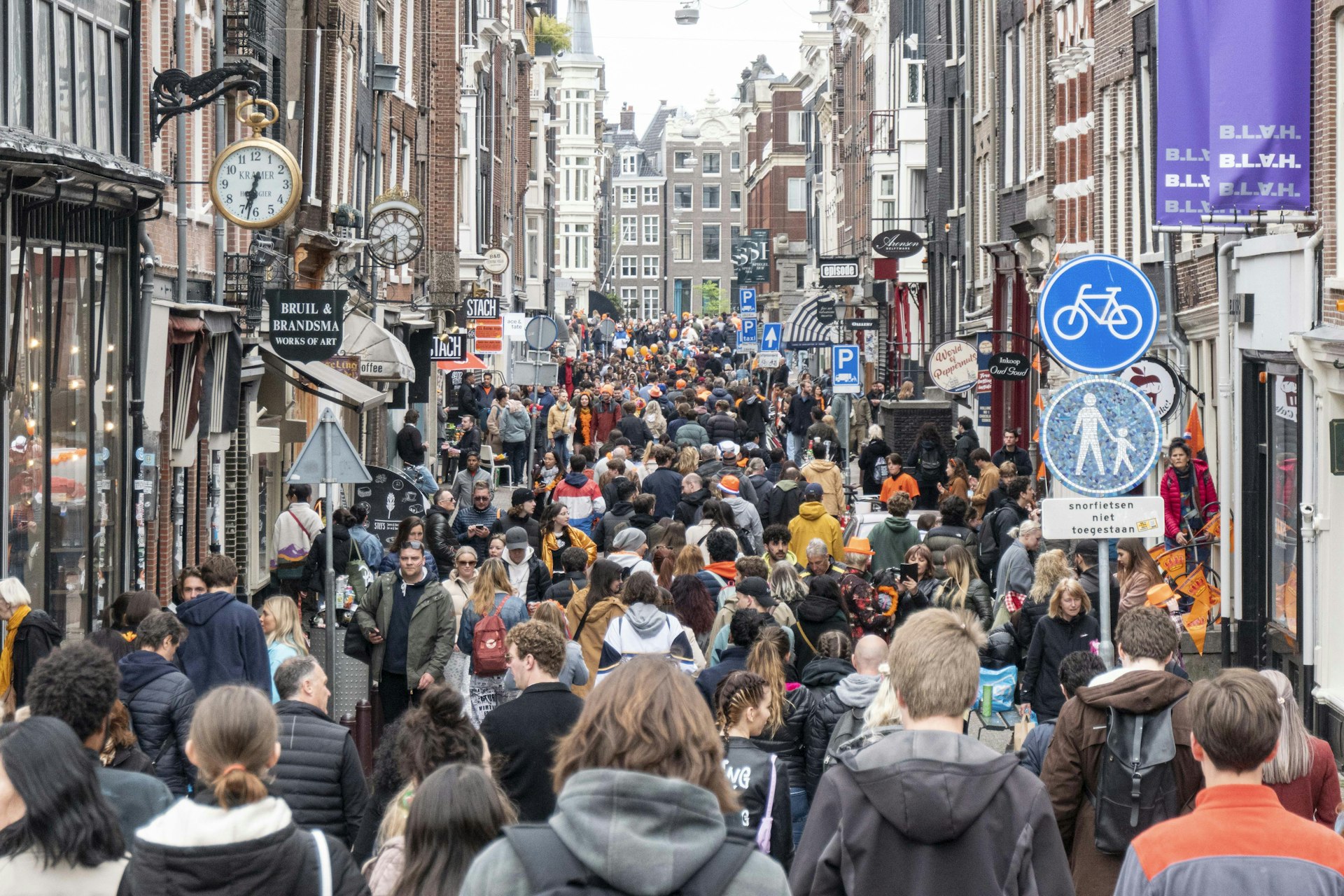 Crowds of people on a narrow street in Amsterdam, the Netherlands