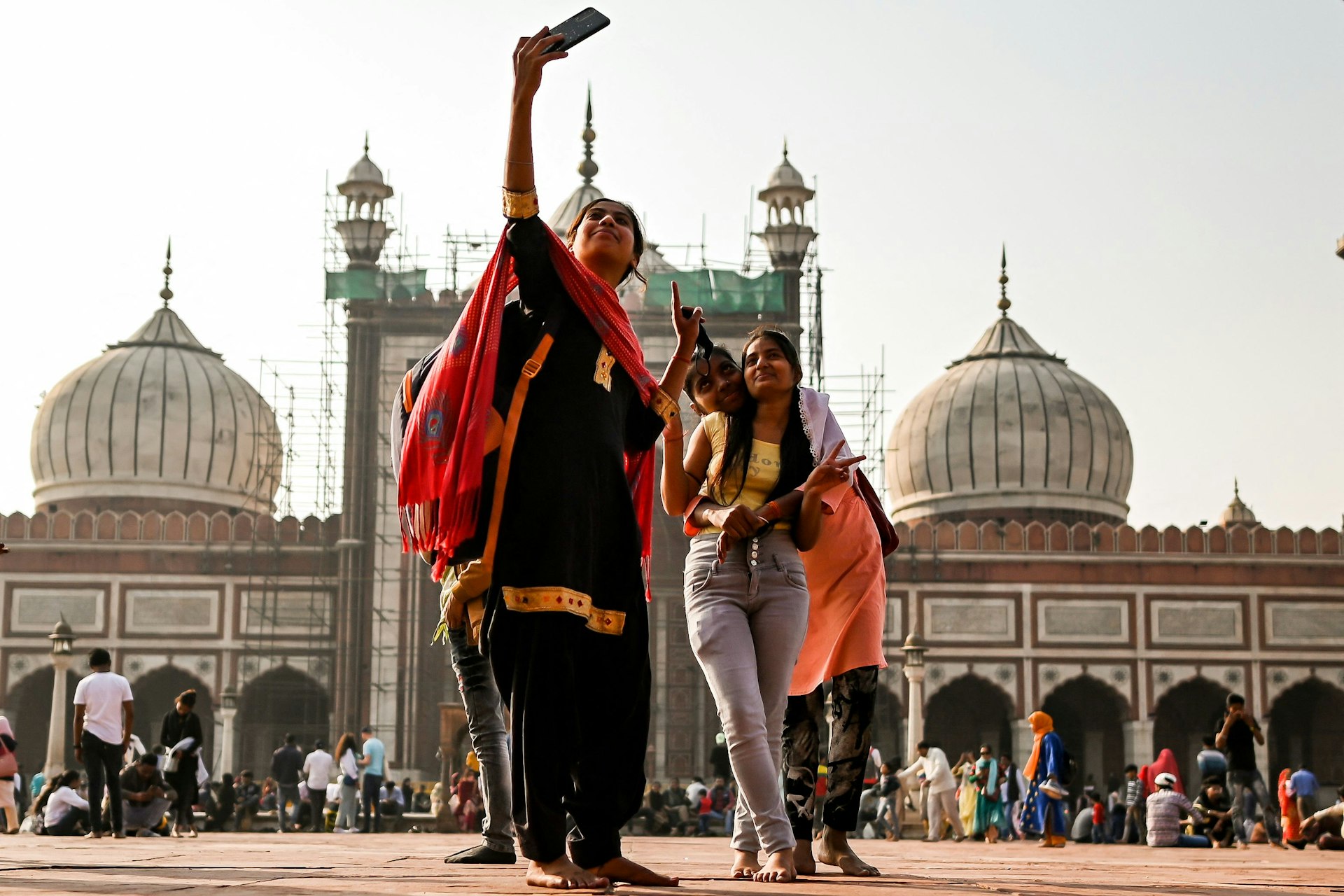A woman with children takes a selfie at Jama Masjid, Delhi, India