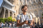 Mid Adult Male Tourist Sightseeing with Camera in Barcelona - stock photo
Bearded male tourist in early 30s holding camera and looking at view while standing in front of Sagrada Familia in Barcelona.