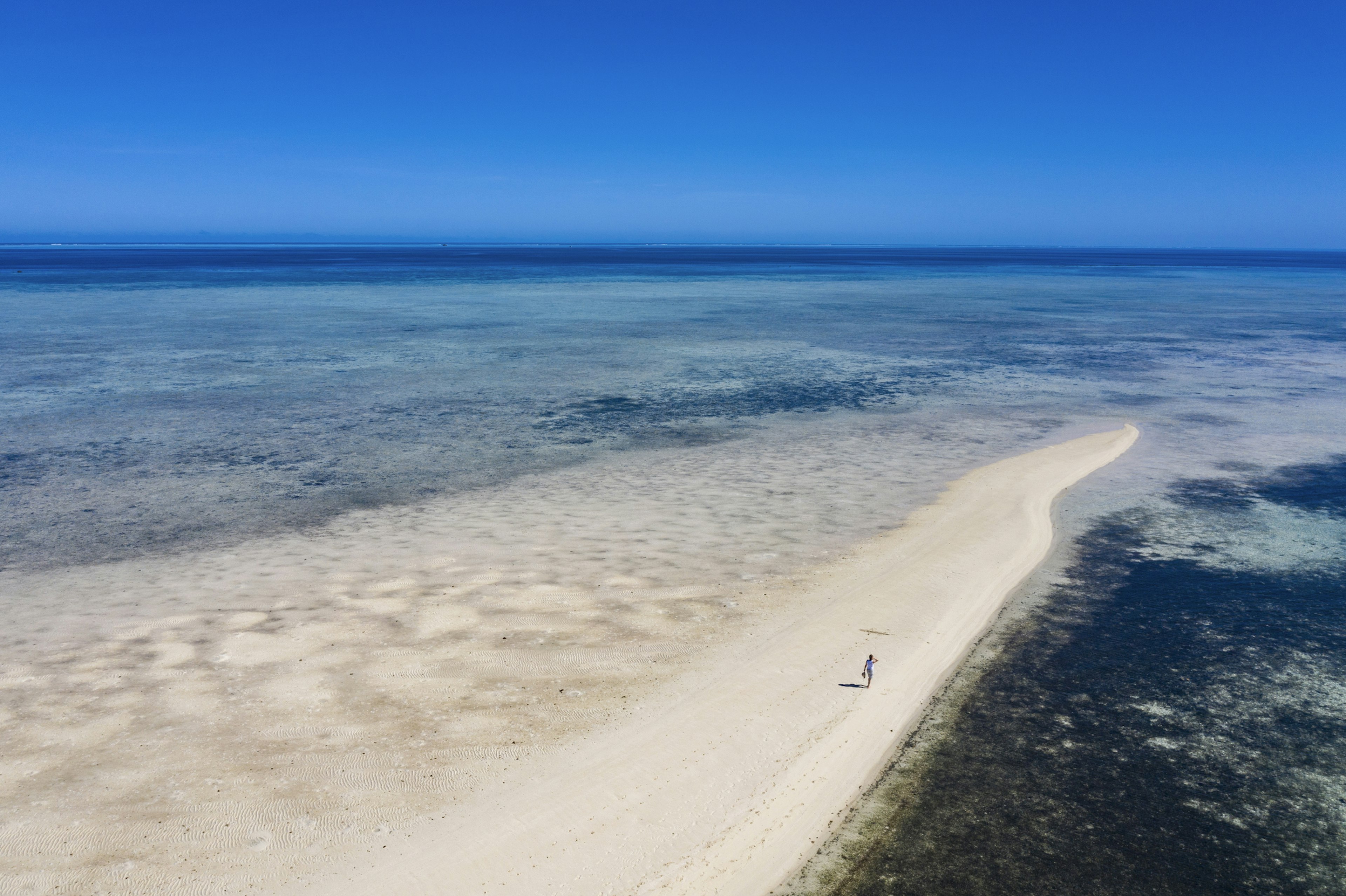 Aerial of woman alone on sandbank during boat excursion from Six Senses Fiji Resort, Malolo Island,