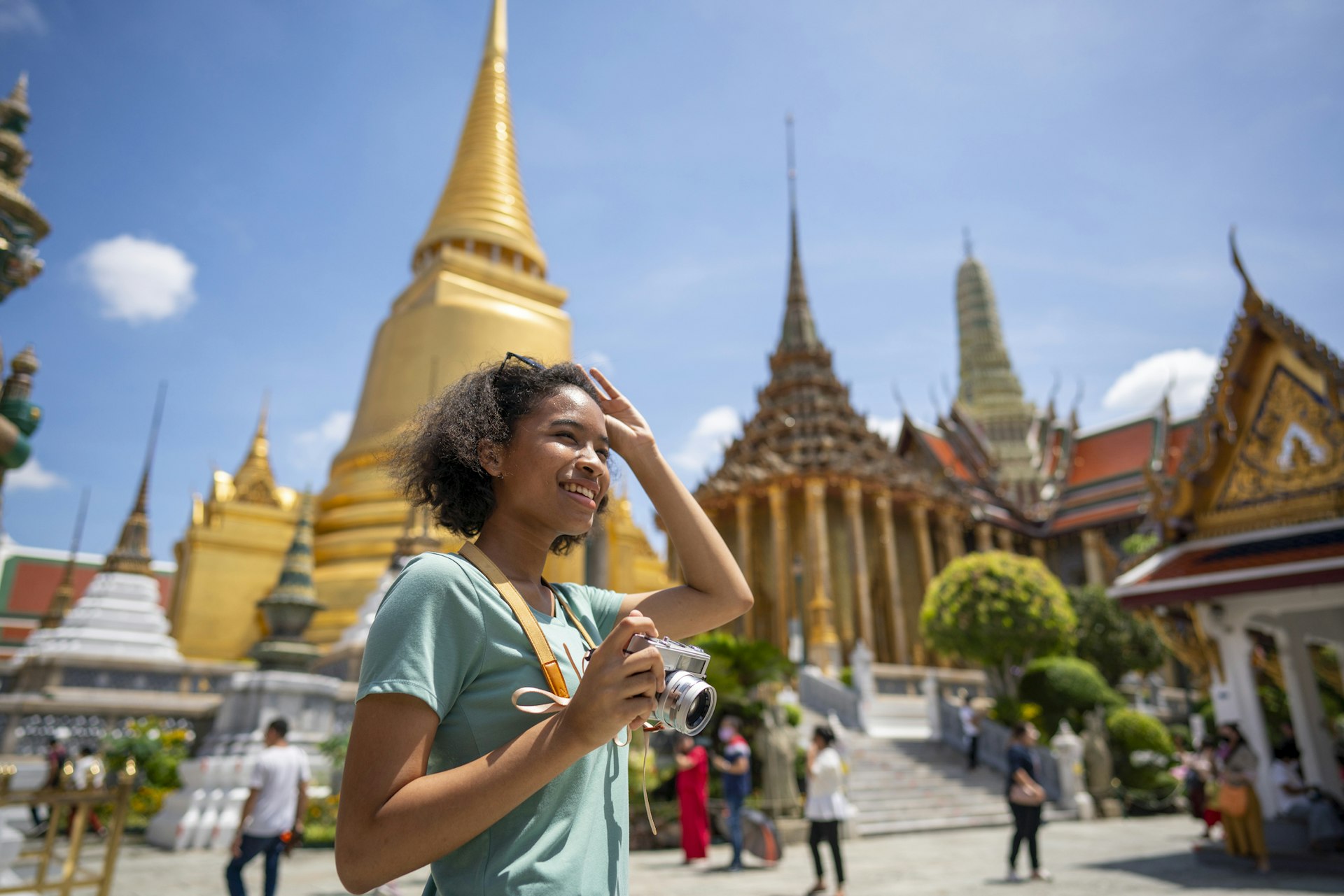 Young woman traveler with backpack traveling into beautiful pagoda in Wat Pra Kaew