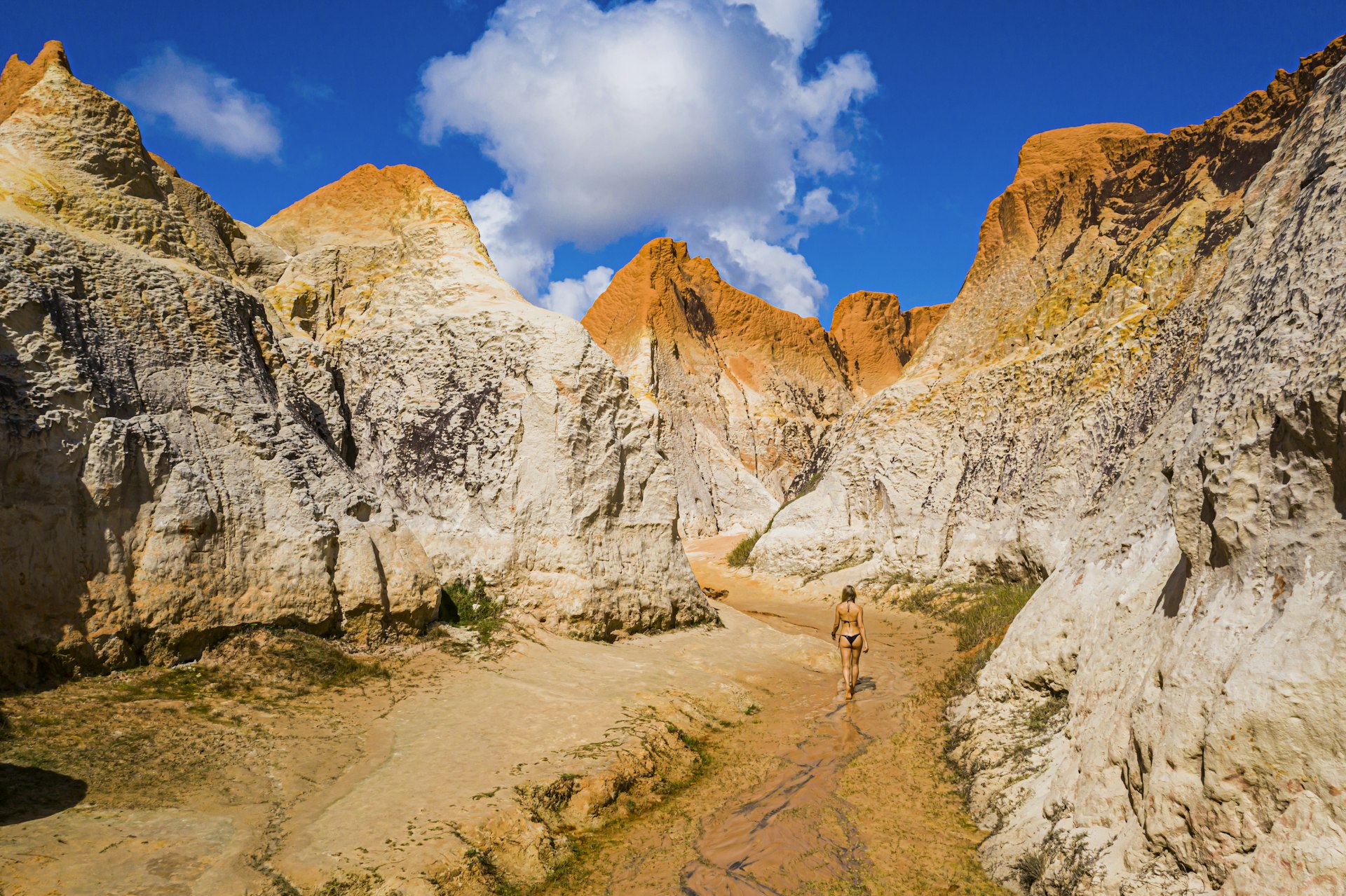 A woman walks into ochre-colored dunes in Ceará, Brazil