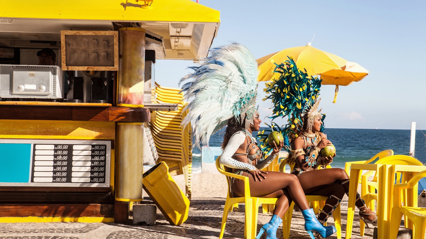 460703271
drinking, sexy, female, woman, dancer, brazil, rio de janeiro, kiosk, costume, carnival, sitting, samba, ipanema beach, brazilian carnival, rio carnival, ipanema, samba dancer, samba girls, samba girl, samba woman, samba women, brazilian culture, taking a break, traditional culture, travel destination, feather, drink, coconut, headdress, entertainment, celebrations, day, 30 to 34 years, outdoors, beach, mid adult woman, only mid adult women, two people, excitement, friendship, traditional, tropical, fun, glamour, luxury, refresh, holding, looking away, turquoise, beauty, decoration, elaborate, revealing, rio de janeiro, brazil
Samba dancers taking a break, Ipanema Beach, Rio De Janeiro, Brazil - stock photo