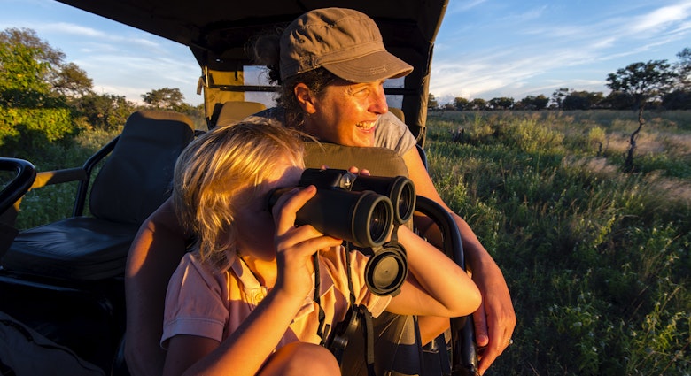 Selinda Reserve, Linyanti Region, Northern Botswana.
617782787
photography, color image, horizontal, outdoors, sunset, side view, sitting, watching, t-shirt, cap, blonde hair, smiling, two people, 6-7 years, 40-44 years, mature women, boys, mother, son, one parent, family with one child, Caucasian ethnicity, cloud, car, 4x4, vehicle interior, safari, bonding, togetherness, binoculars, sky, elementary age, Selinda Reserve, Linyanti Region, Northern Botswana
A mother and son on safari in the Selinda region in Botswana
