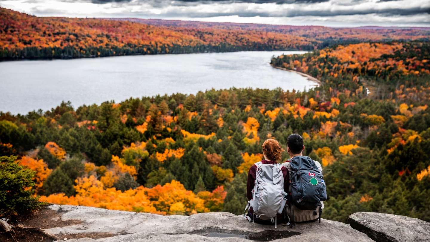 Young couple hiking in mountain and relaxing looking at view in the Algonquin Park, Ontario - Canada.
621242410
Couple - Relationship, Real People, Travel, Tourism, Outdoor Pursuit, Non-Urban Scene, Looking At View, Young Women, Women, Females, Young Men, Men, Males, Two People, Weekend Activities, Beauty In Nature, Algonquin Provincial Park, Young Adult, Adult, Backpack, Sitting, Scenics, Caucasian Ethnicity, Togetherness, Happiness, Romance, Friendship, Adventure, Exploration, Tranquil Scene, Travel Destinations, Nature, Outdoors, Rear View, Mountain Climbing, Hiking, Recreational Pursuit, People, Ontario - Canada, Canada, Autumn, Season, Mountain Peak, Mountain, Woodland, National Park