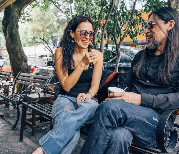 Woman and man sitting and chatting on a bench in the Coyoacán neighborhood of Mexico City.