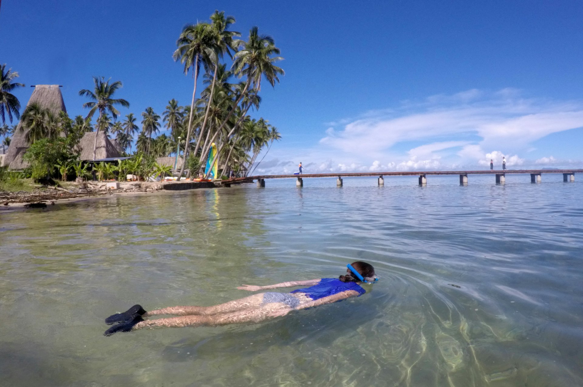 A woman snorkels in the waters off a tropical island