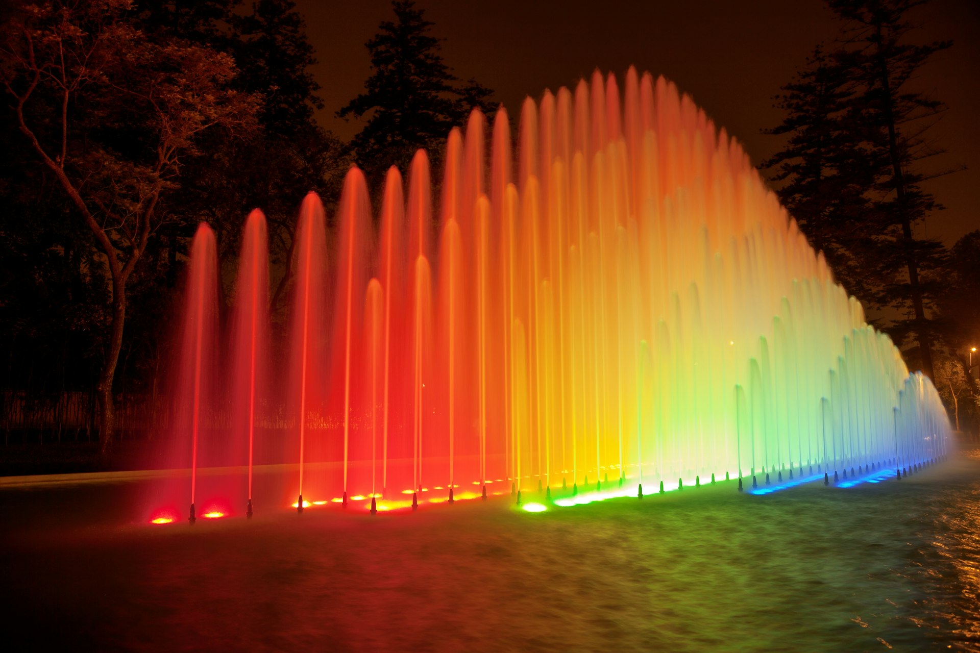 Water fountains lit up with bright colors at night in the Magic Water Circuit Park, Lima