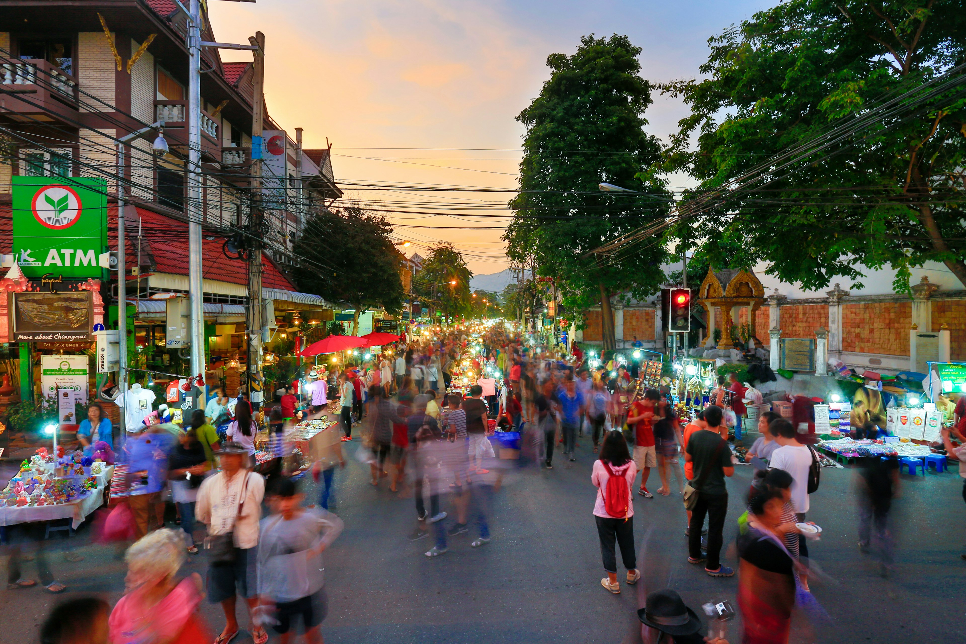 Long-exposure of a crowd of people exploring Sunday market walking street.