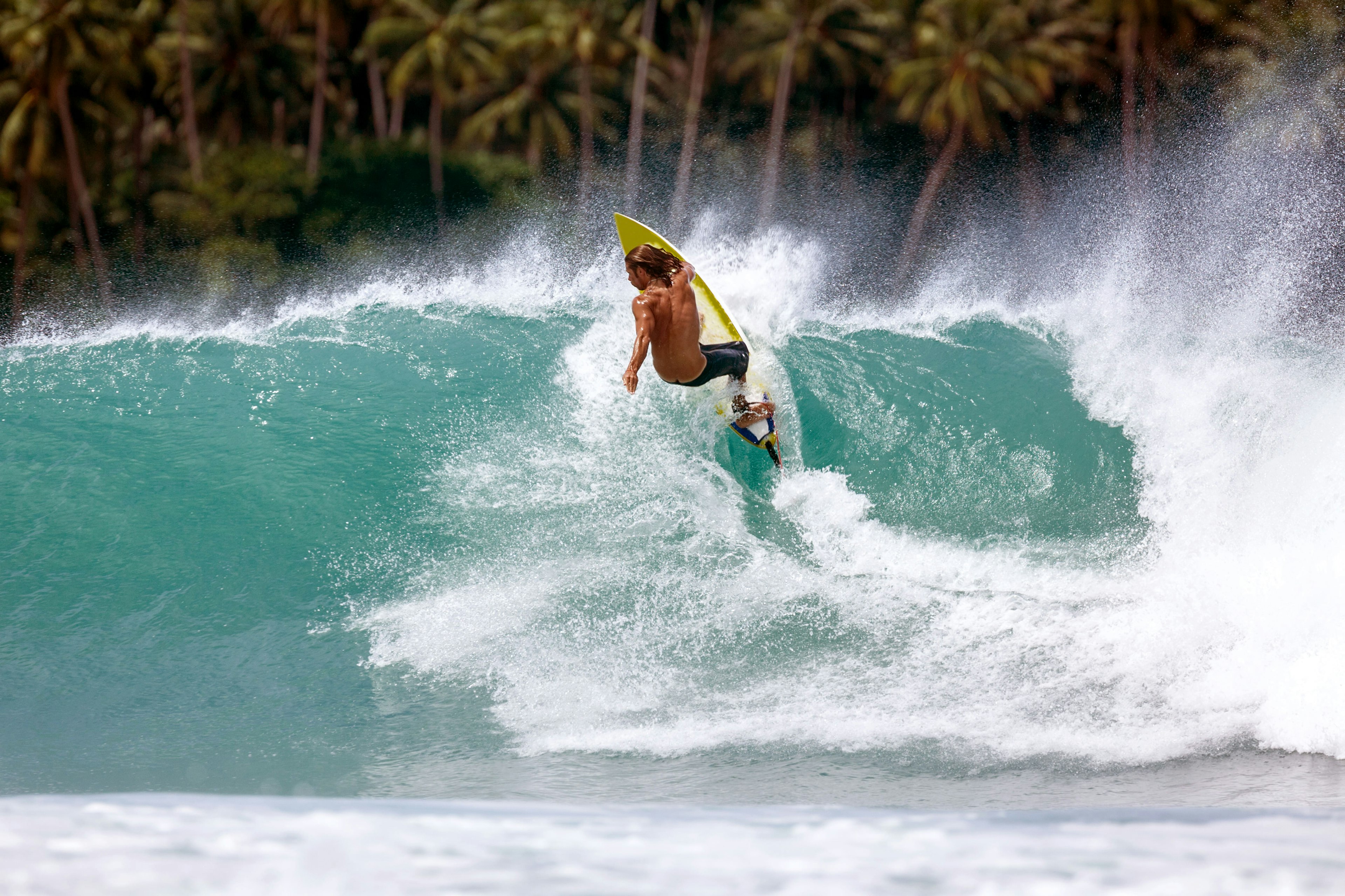 A man surfs in North Sumatra, Indonesia at Lagundri Bay