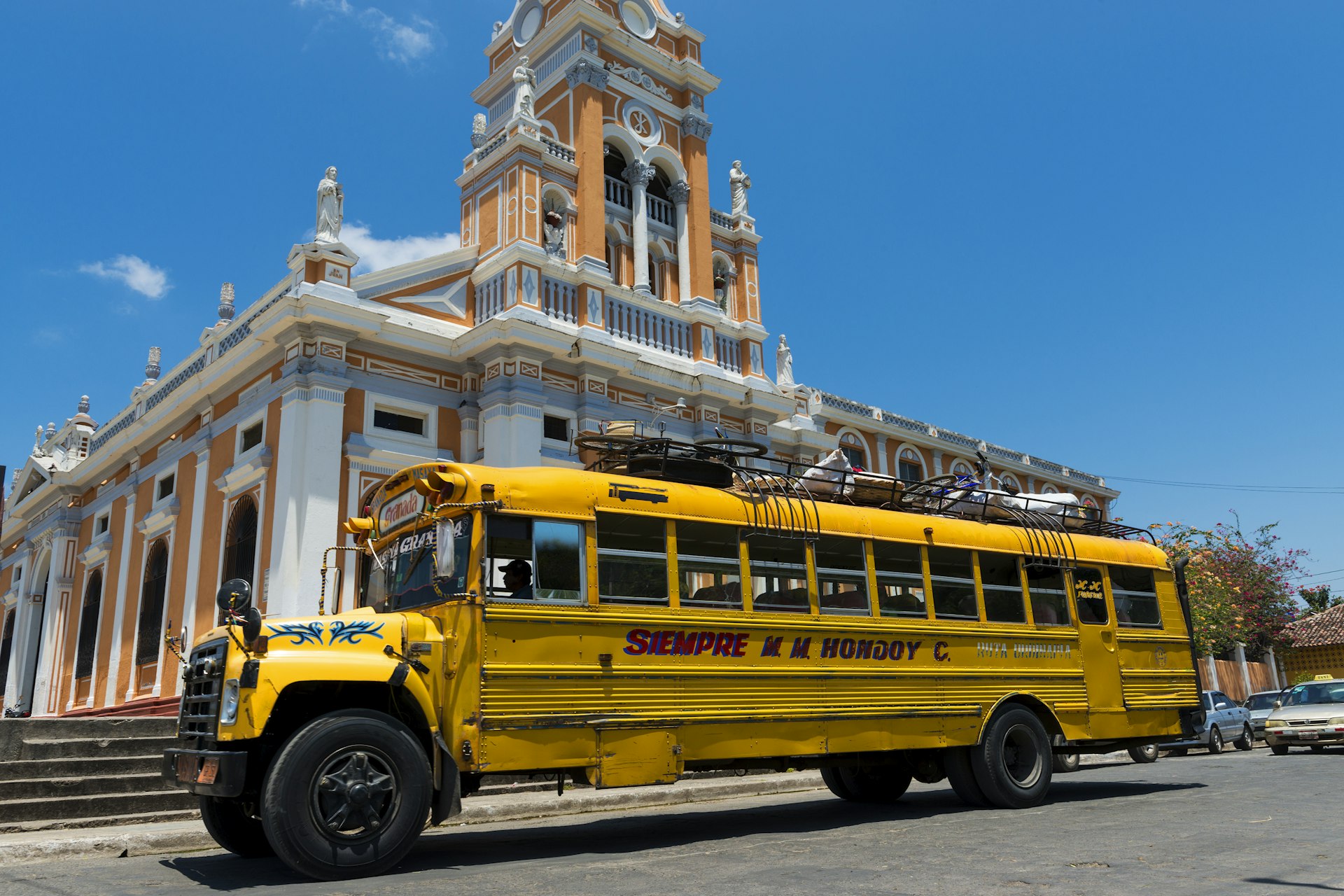 Yellow bus in front of a church in Granada, Nicaragua