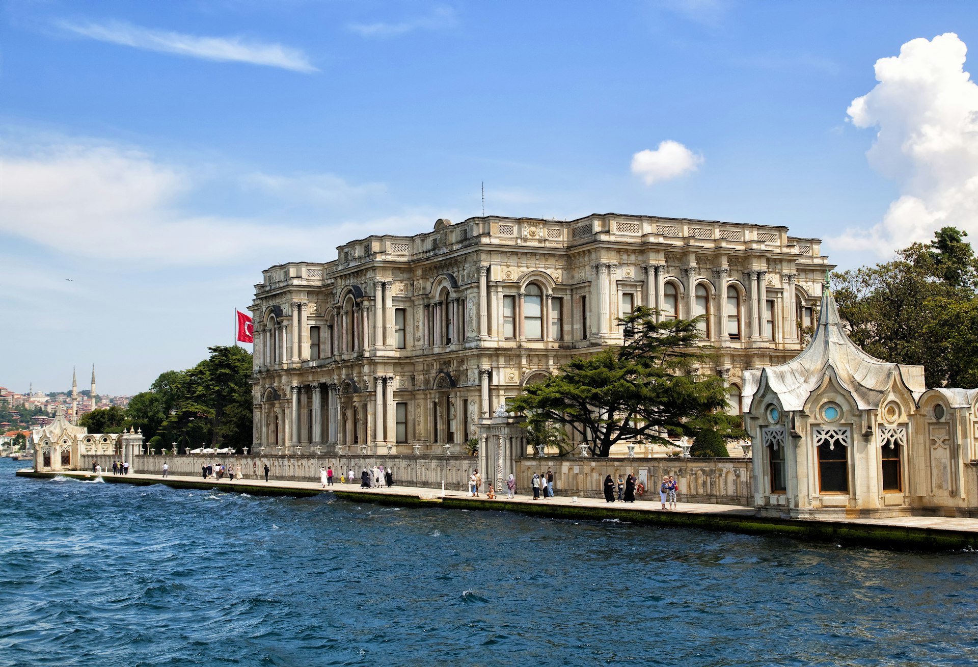 Pedestrians walking on the parade outside a Palace on the Bosporus shores in Istanbul