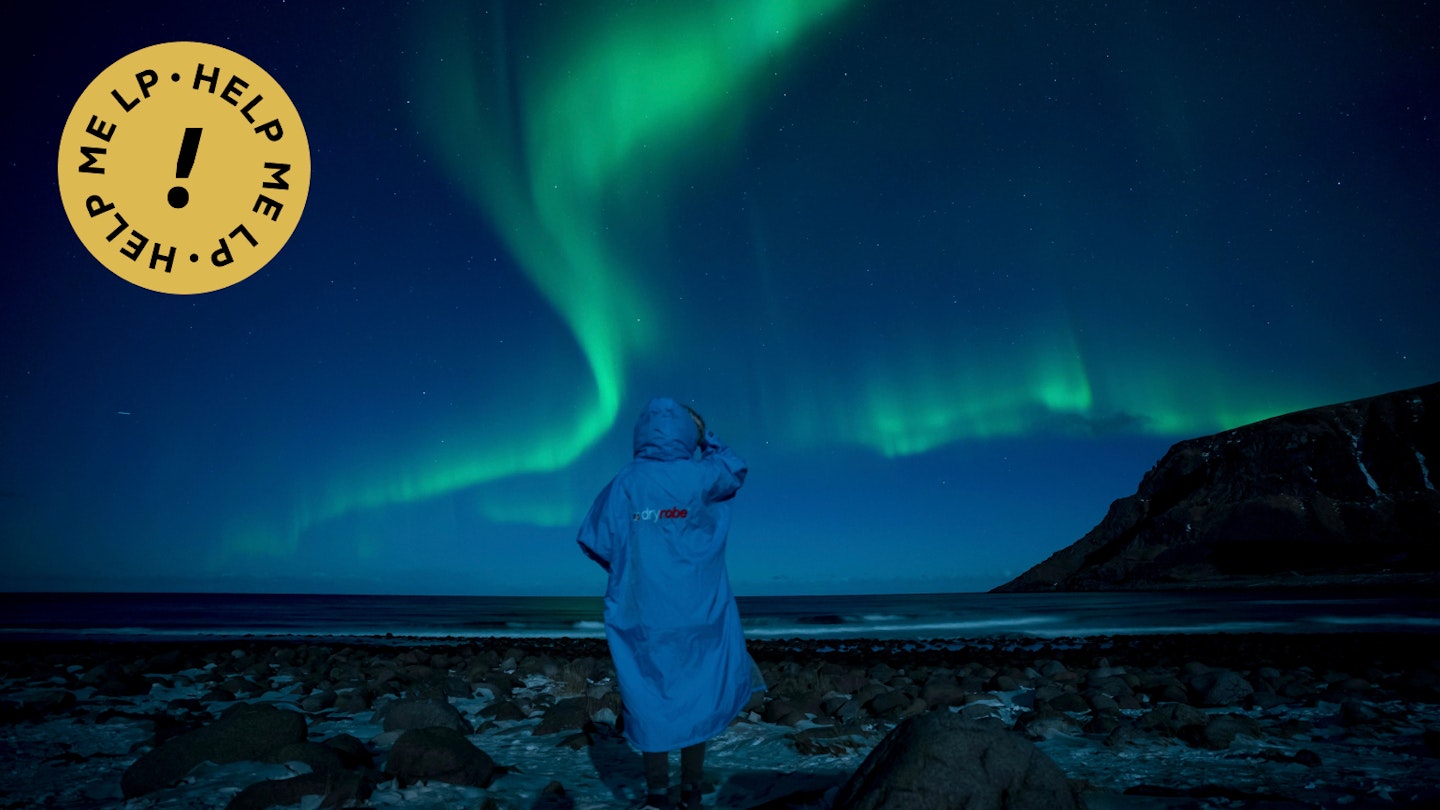 A person watches northern lights (Aurora borealis) on March 3, 2018 in Unstad, in the arctic circle in northern Norway.