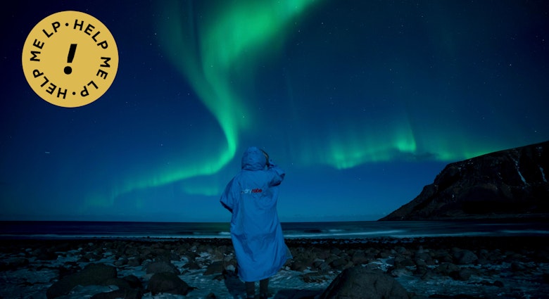 A person watches northern lights (Aurora borealis) on March 3, 2018 in Unstad, in the arctic circle in northern Norway.