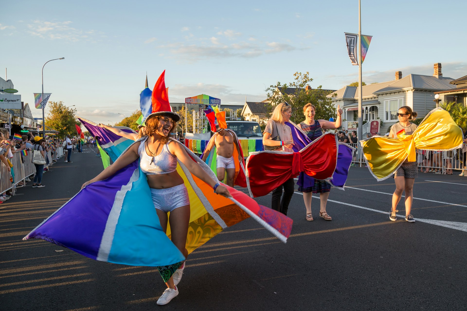 People dressed in rainbow colors celebrate and dance in the streets