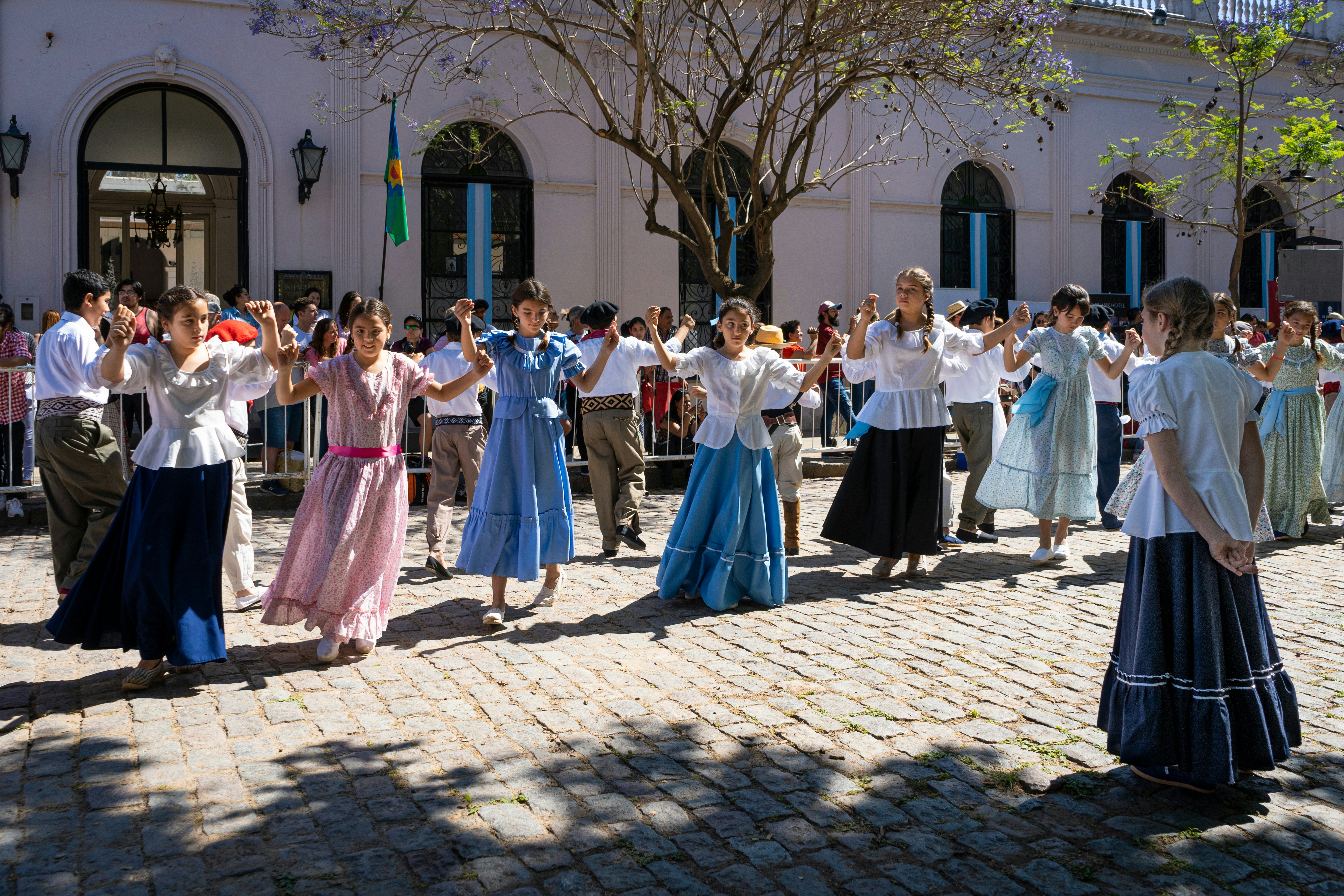 Children in traditional dress dancing Argentine dances on a cobblestone street in San Antonio de Areco, Buenos Aires Province, Argentina