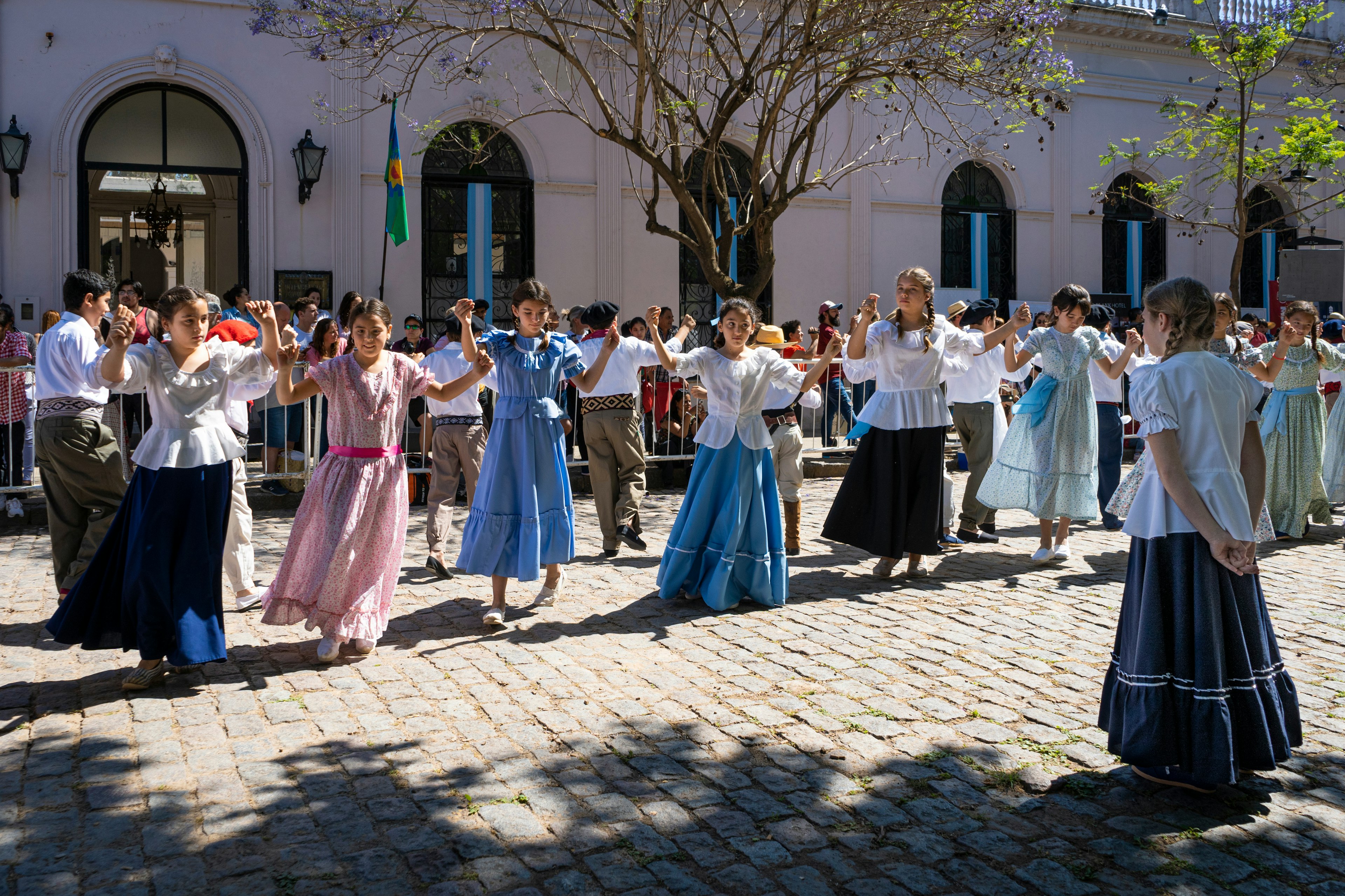 Children in traditional dress dancing Argentine dances on a cobblestone street in San Antonio de Areco, Buenos Aires Province, Argentina