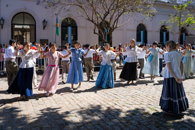 Children in traditional dress dancing Argentine dances on a cobblestone street in San Antonio de Areco, Buenos Aires Province, Argentina