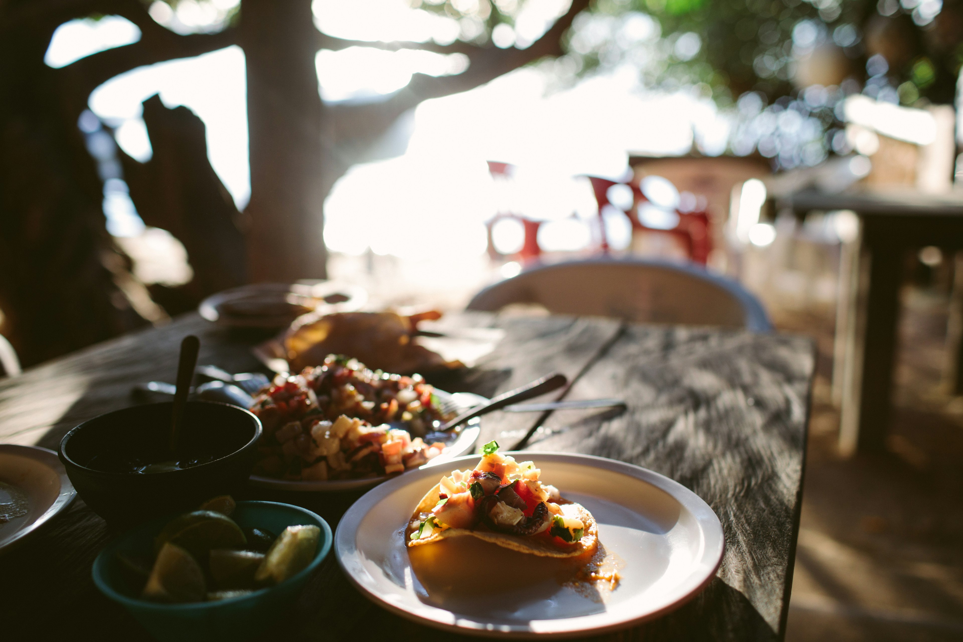 A close-up of traditional tacos at a restaurant with a beach setting in Cancún