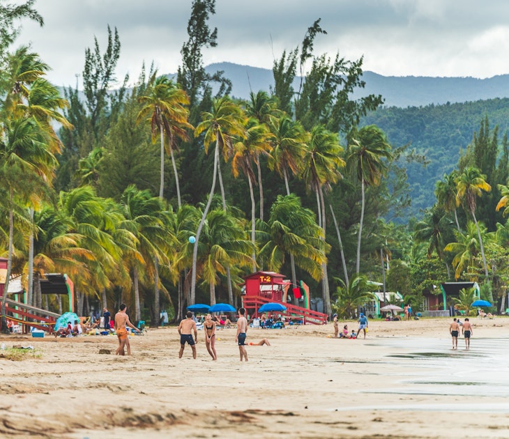 Luquillo, Puerto Rico - February 11 2021: People enjoying activities at Luquillo beach in Puerto Rico against tropical background of Luquillo mountains and green palm trees. Wide High quality photo
2317964417