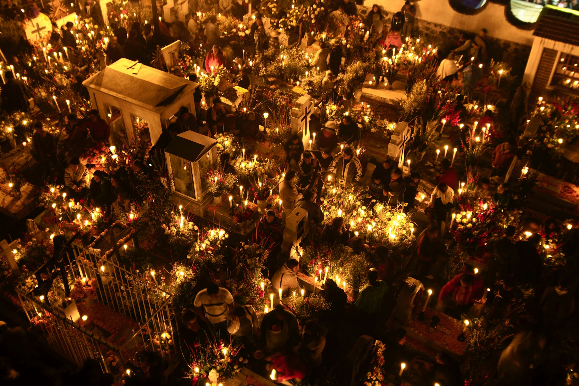 Illuminated by candles, crowds gather for commemorations during the Day of the Dead at the Church of San Andres Apostol cemetery, Mexico