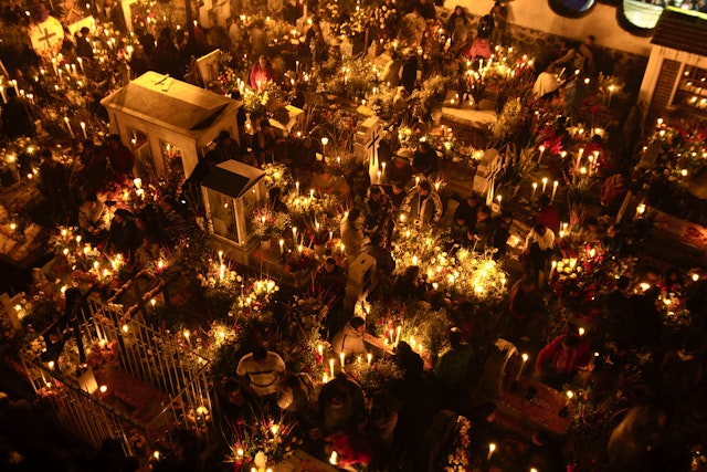 Gravesites illuminated by candlelight during Day of the Dead celebrations in San Andres. Shutterstock