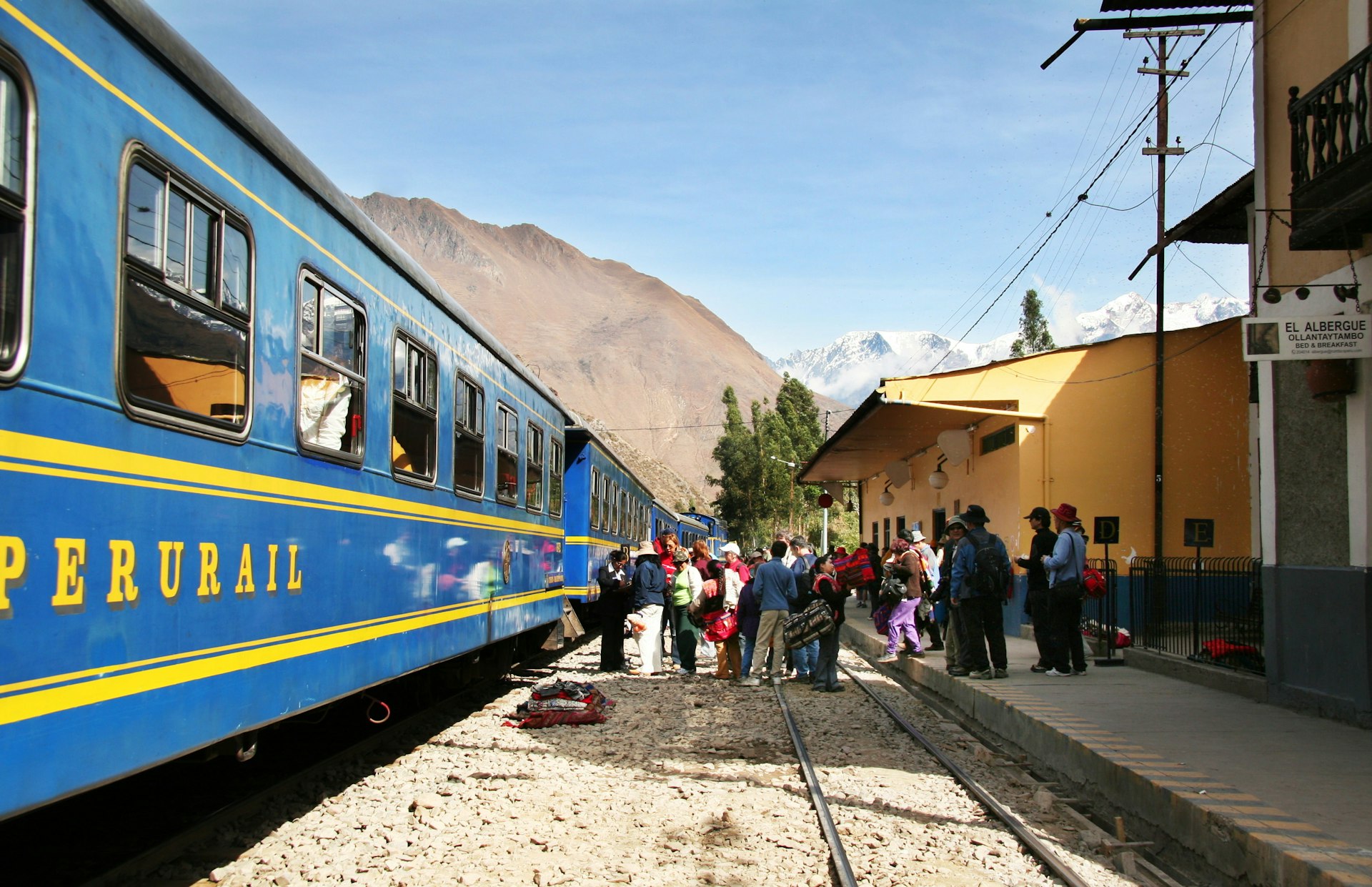 Passengers line up to board a blue train in the Machu Picchu city, Peru