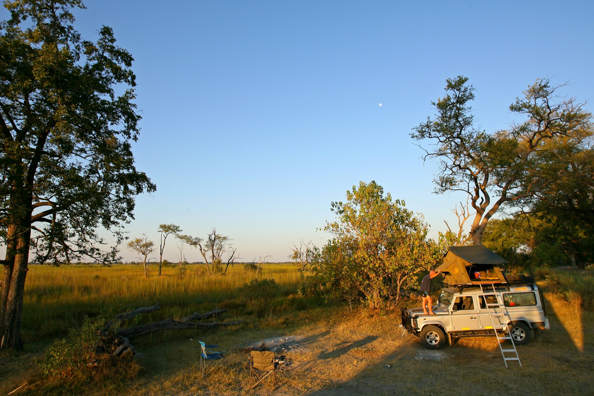 Setting up camp in the Moremi game reserve with a tent on top of a 4WD in Bostwana