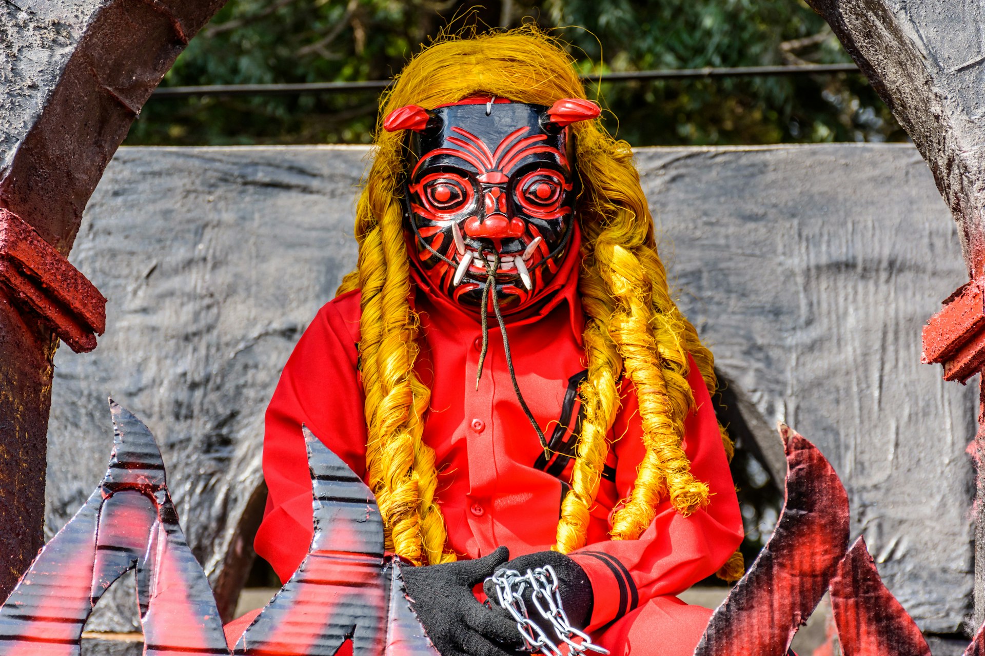 A local doing a traditional folk dance wears a devil mask and costume in Ciudad Vieja, Guatemala 