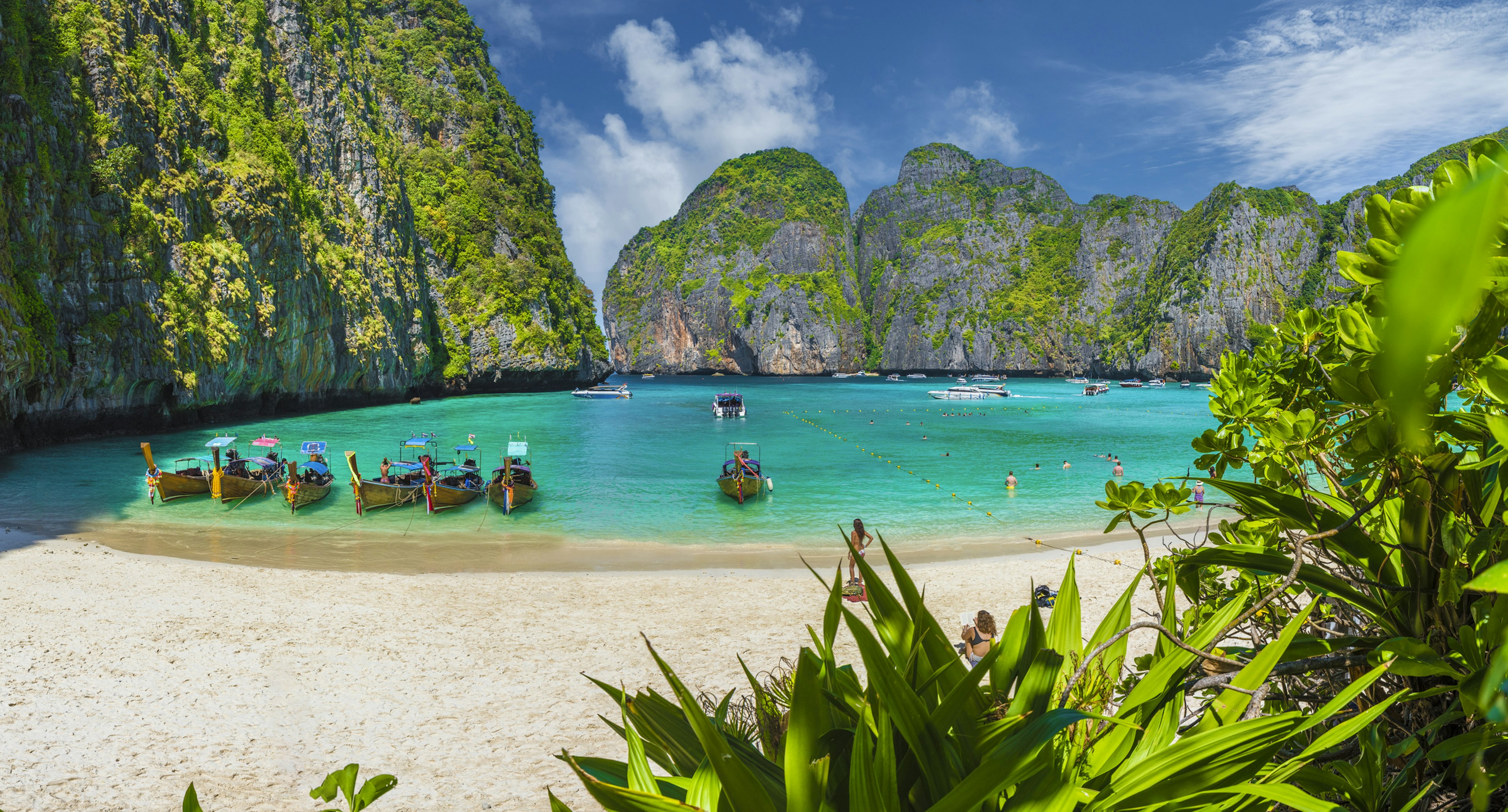 A gorgeous beach scene with white sands, turquoise waters and large rocky outcrops