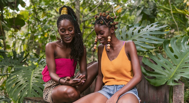 Young ladies hanging out under the tropical sunshine in Jamaica, Laughing, hairstyling each others hair smiling and happy...Photography by Nickii Kane for New wave JA.
1142811942