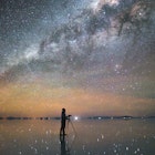 1145977847
A person taking a photo of the Milky Way reflected in the salt flats in Uyuni, Bolivia
